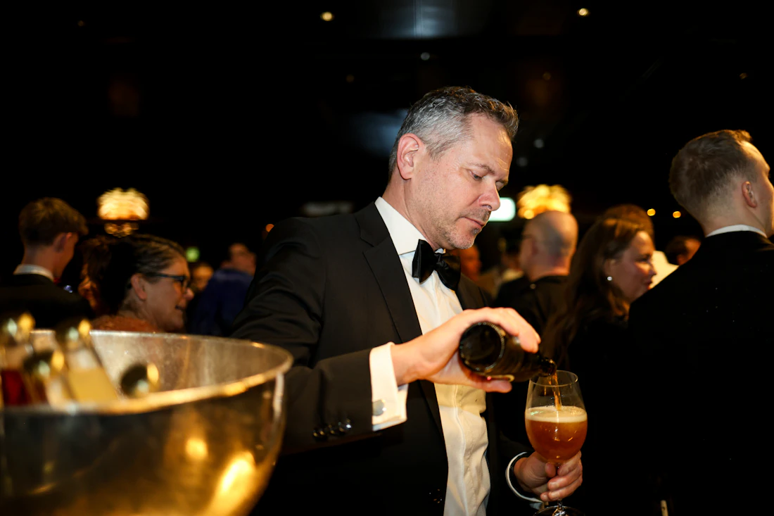 Bartender in formal attire serving drinks at an evening function