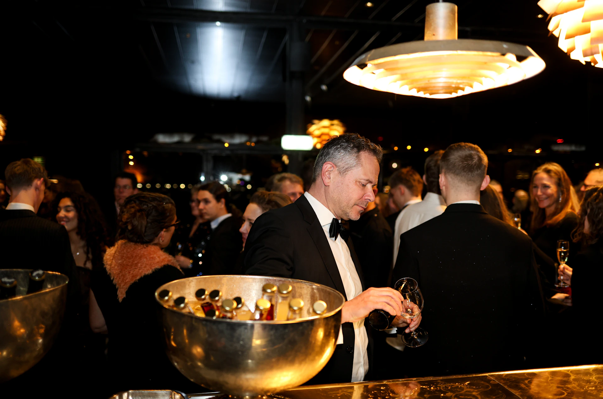 People mingling at a formal event with champagne.