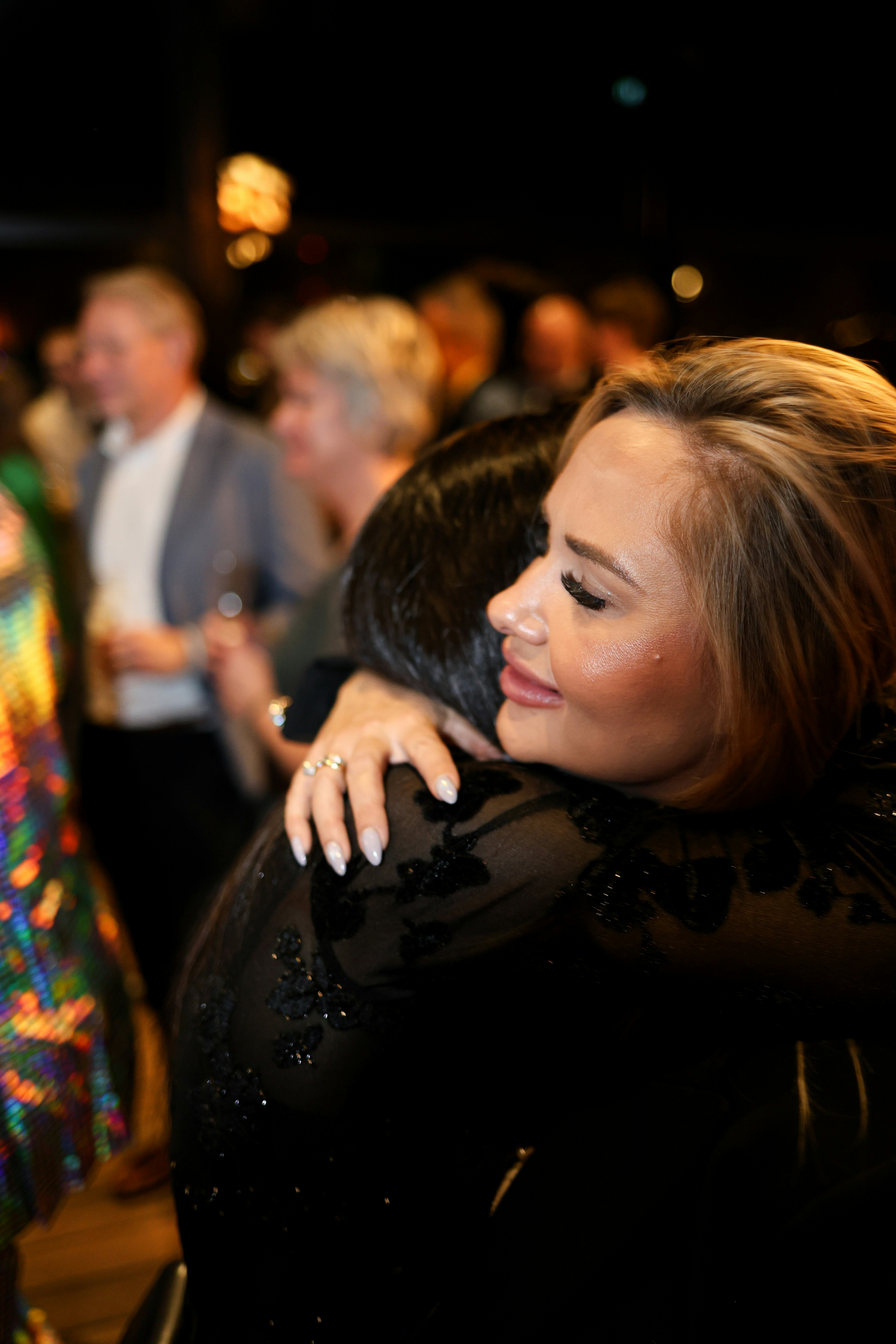 Zwei Frauen, die sich bei einer Veranstaltung herzlich umarmen