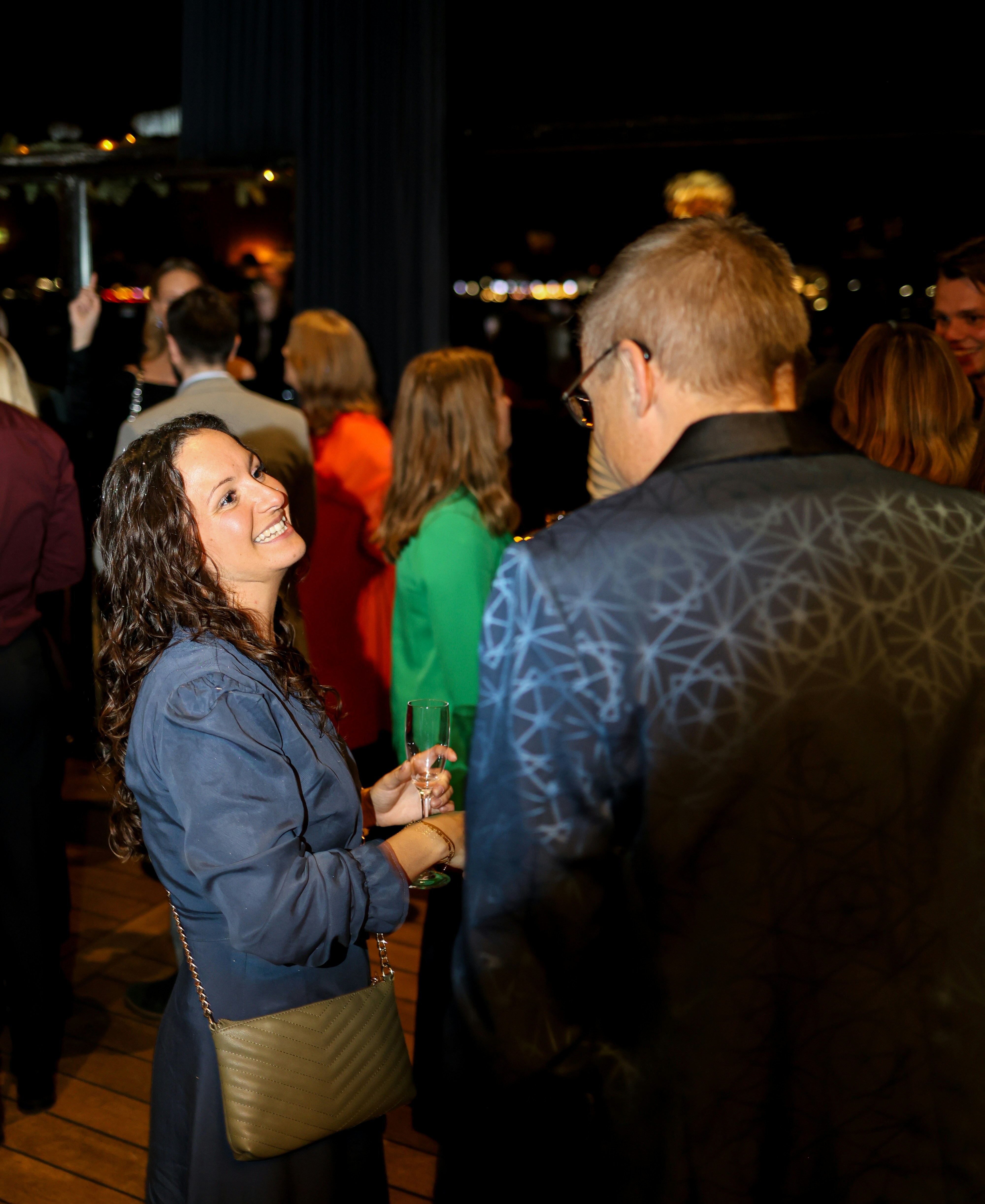 A woman in a blue dress talks to a man