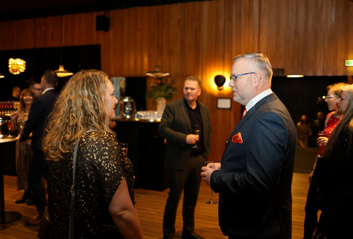 People mingling at a formal event with drinks