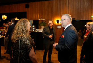 People mingling at a formal event with drinks