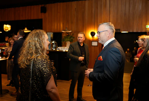 People mingling at a formal event with drinks