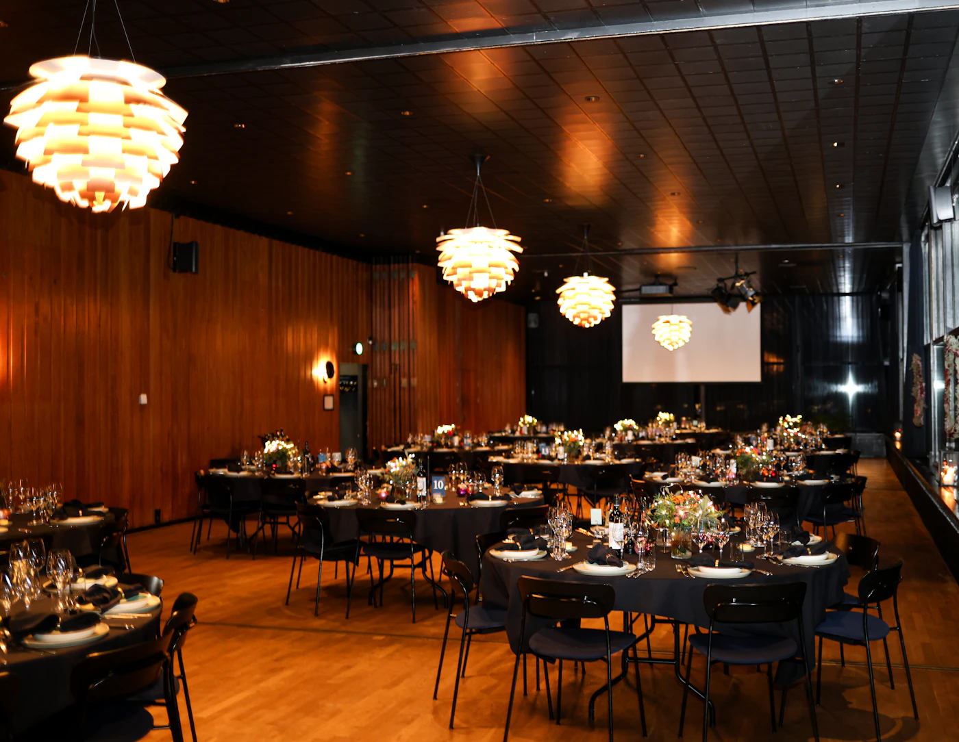 Formal event venue set with tables and elegant lighting