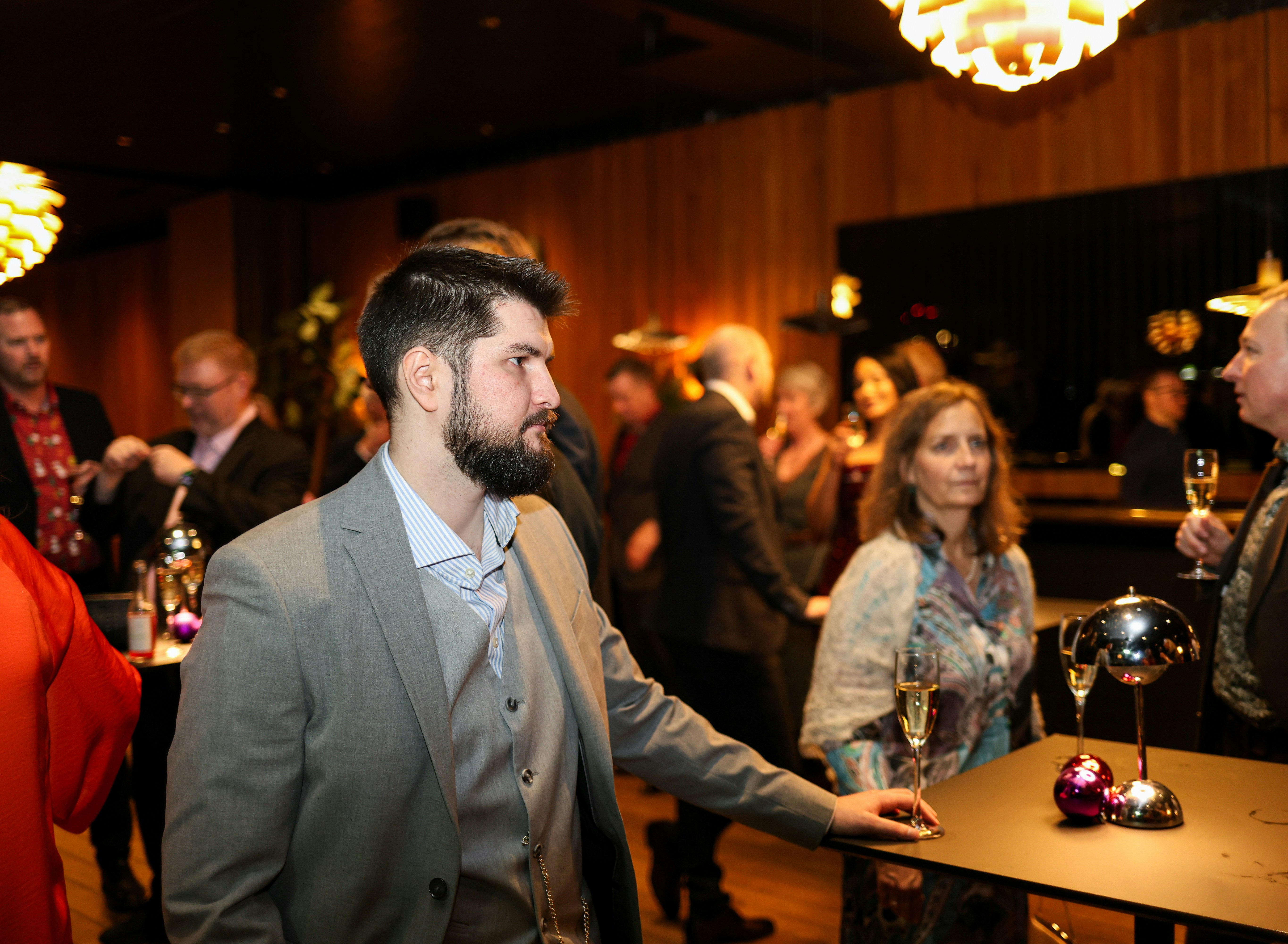 People mingling at a formal event with drinks.