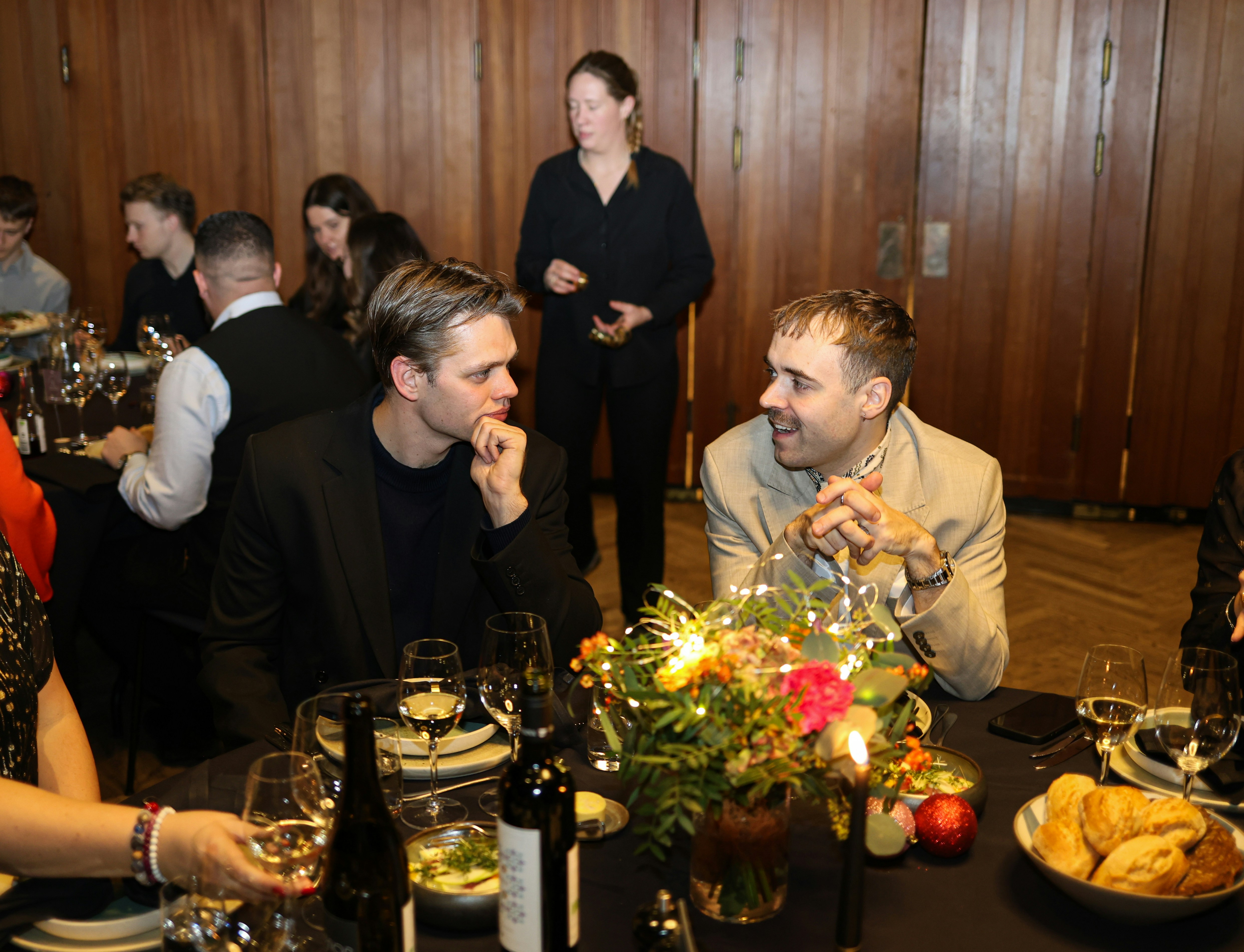 Two men talking at a formal dinner party