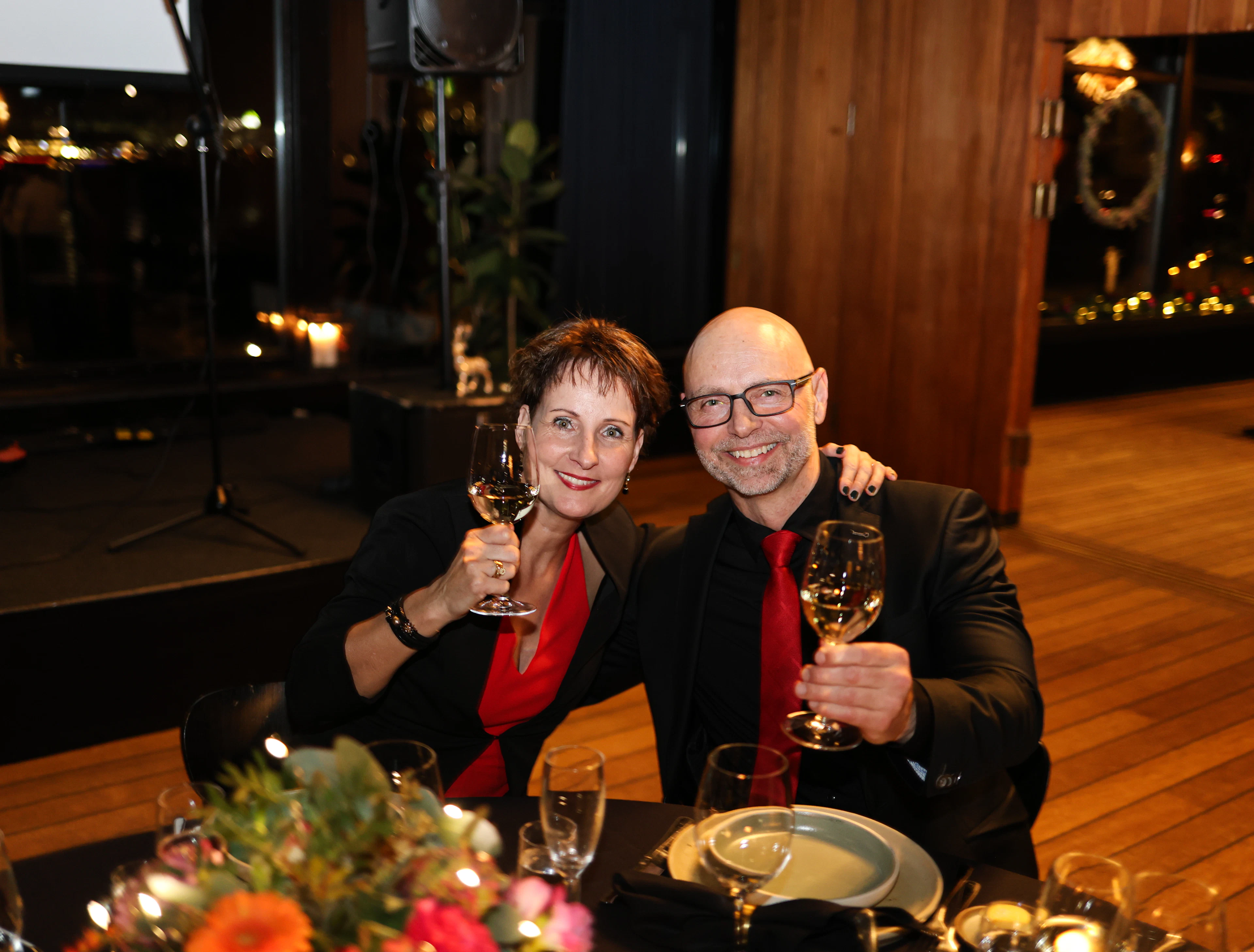 A couple raising wine glasses at a formal dinner