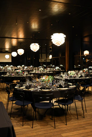 A formal dining setup with round tables and chairs.