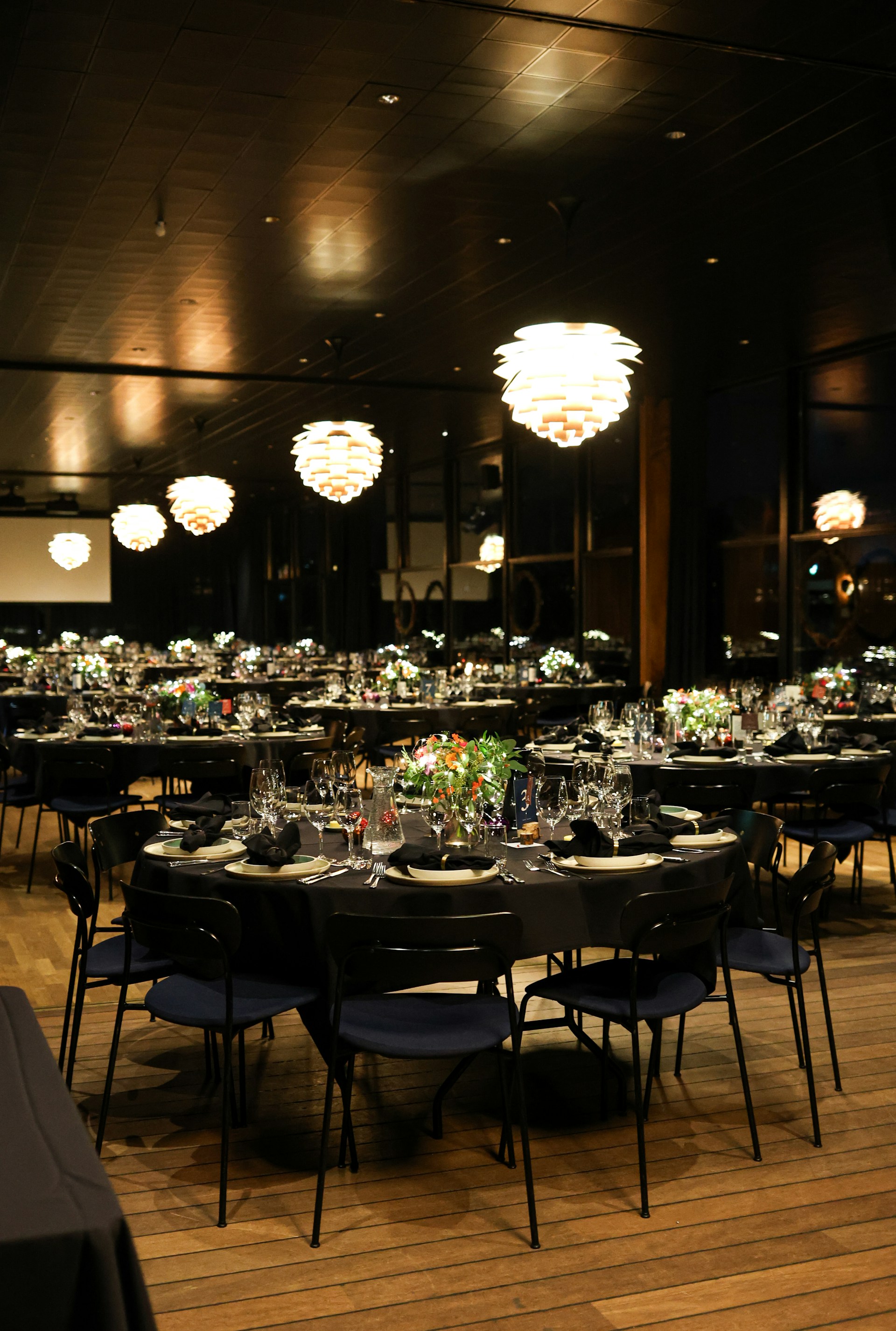 A formal dining setup with round tables and chairs.