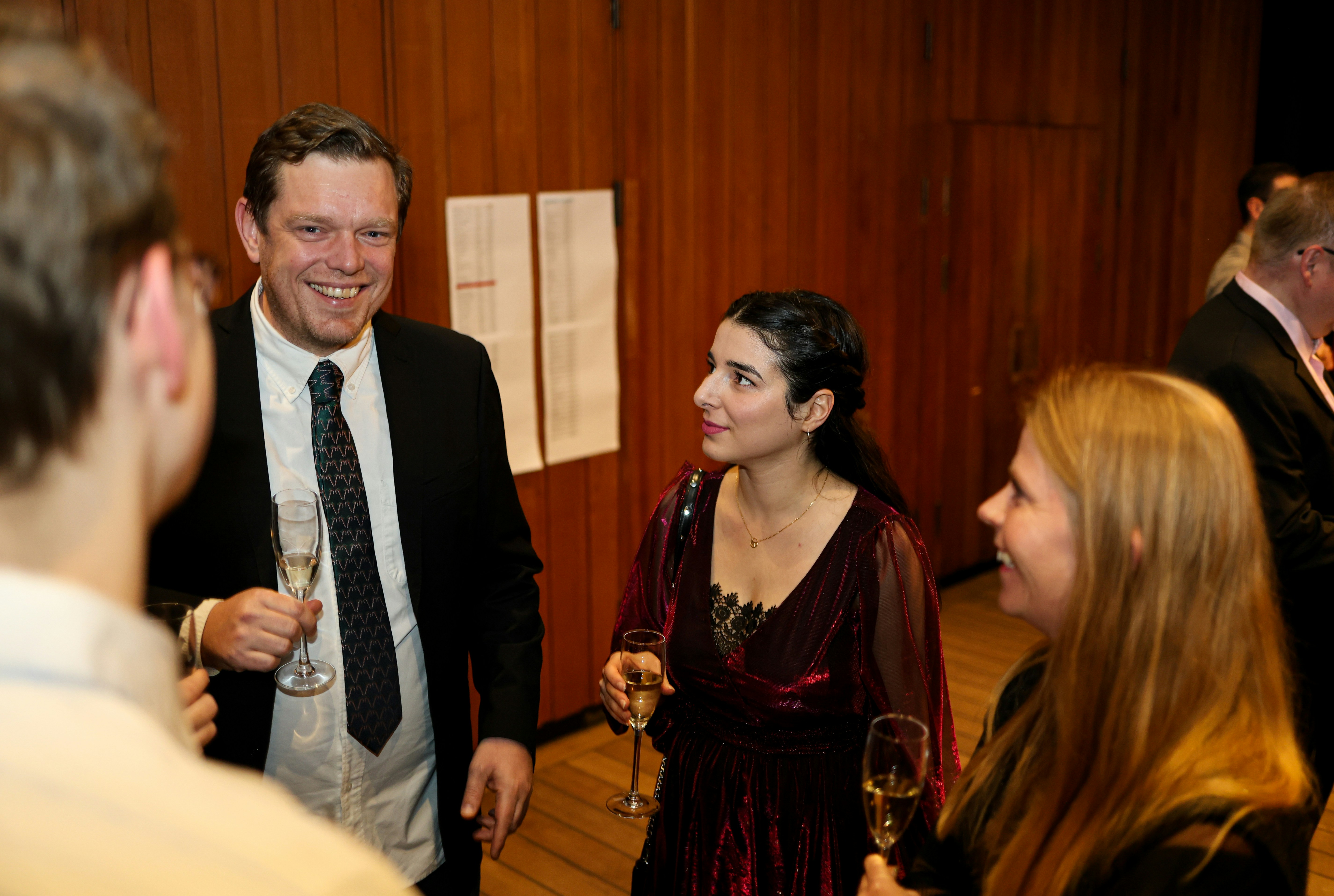 People talking and holding champagne glasses at an event