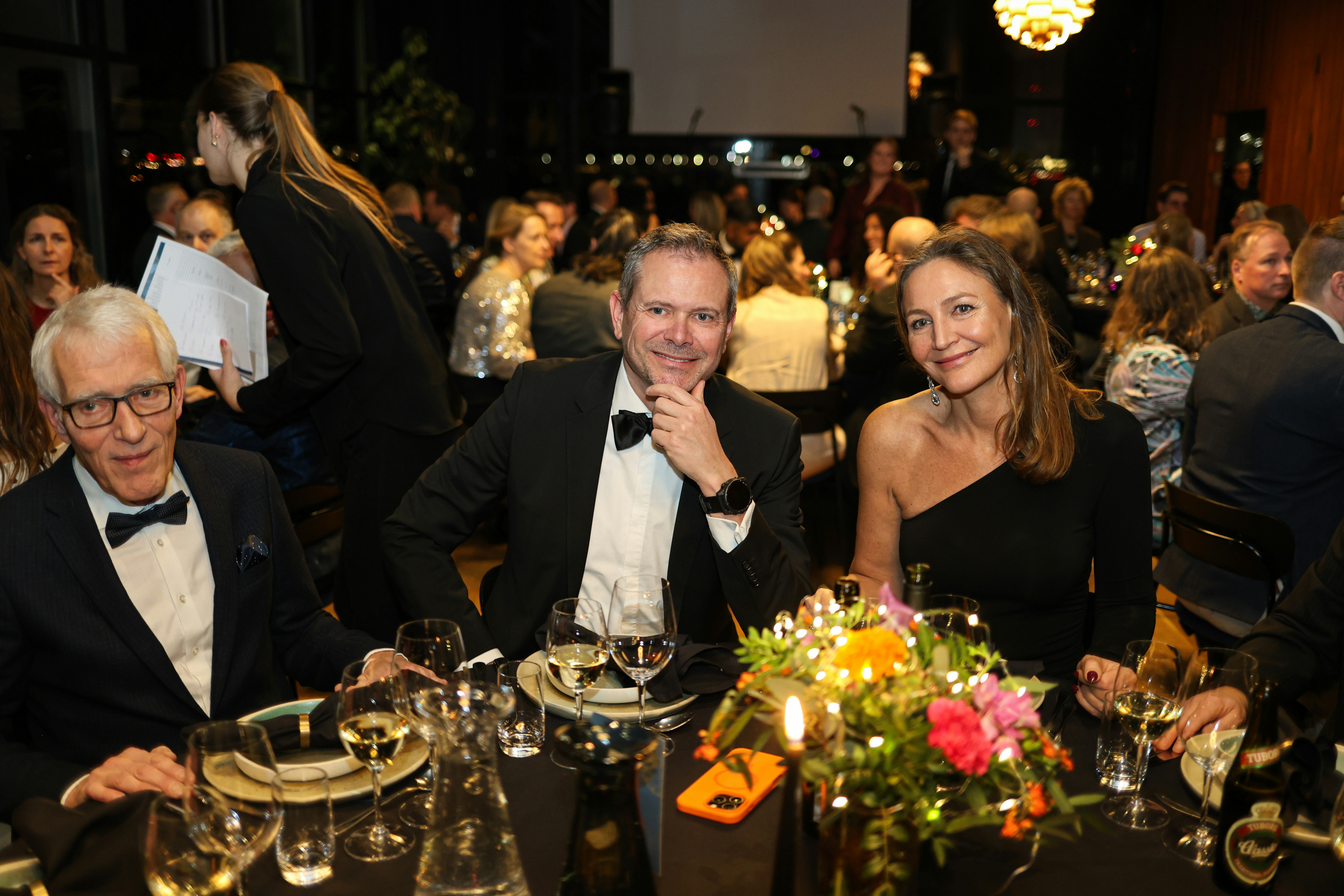 Three people at a formal dinner event