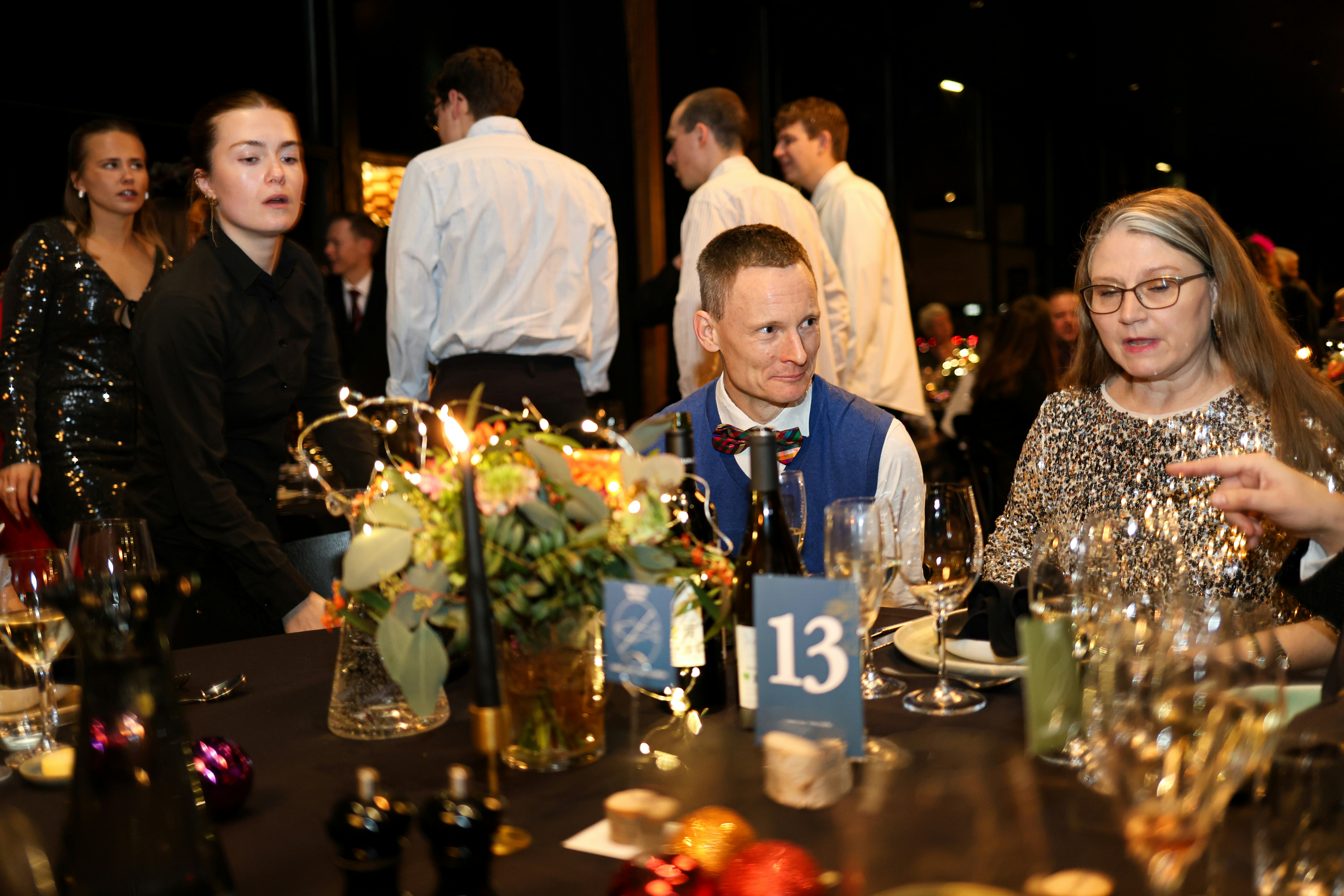 People gathered at a formal dinner event with decorations.