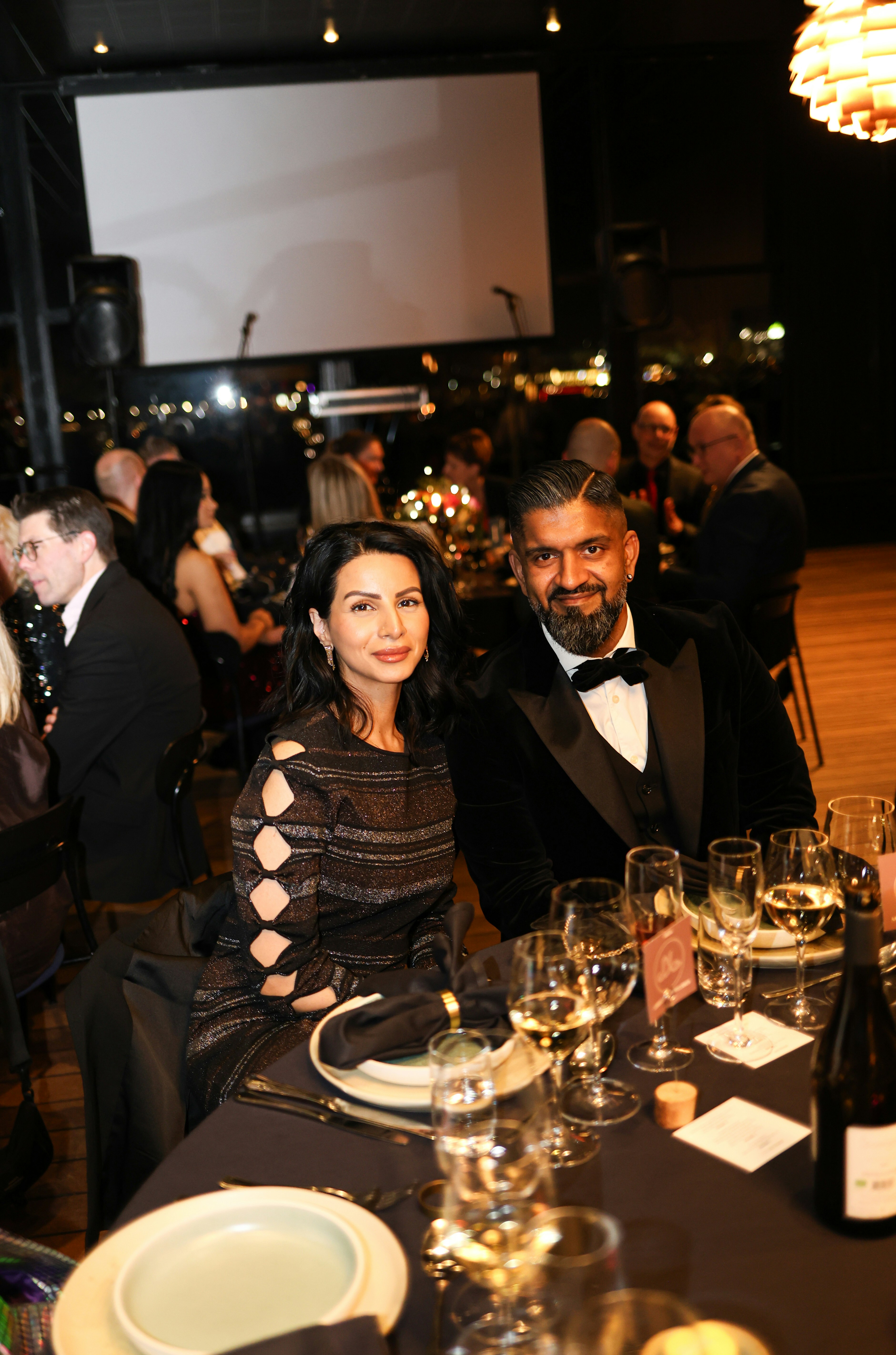 A couple dressed formally at a dinner table