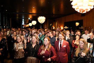 A crowd of people gathered indoors at an event.