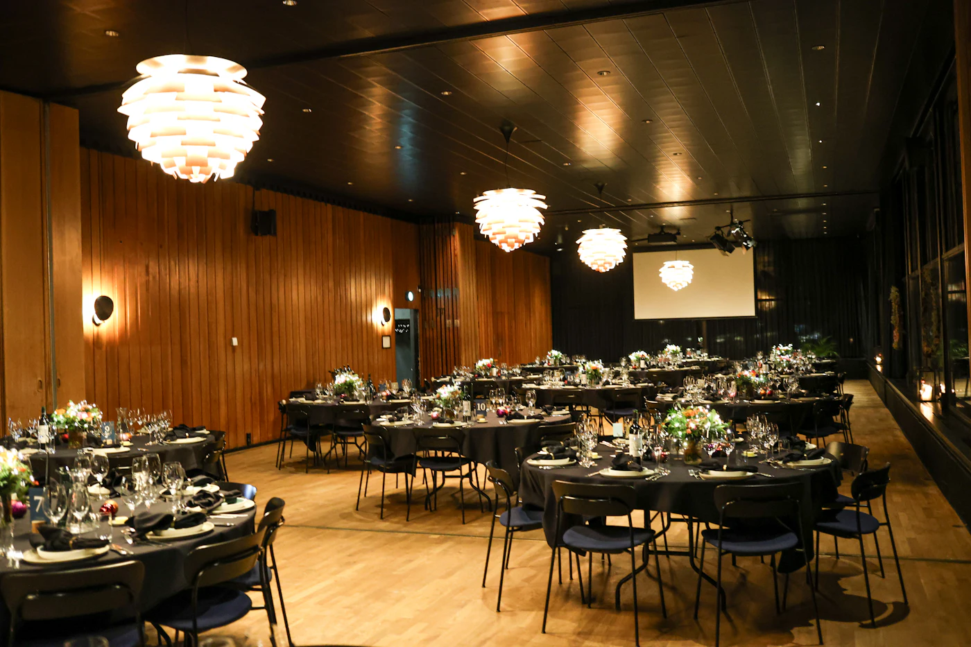 The wood-panelled Durbar Hall set with round tables beneath paper-lantern pendants