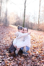 A mother and child in a forest during autumn