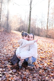 A mother and child in a forest during autumn