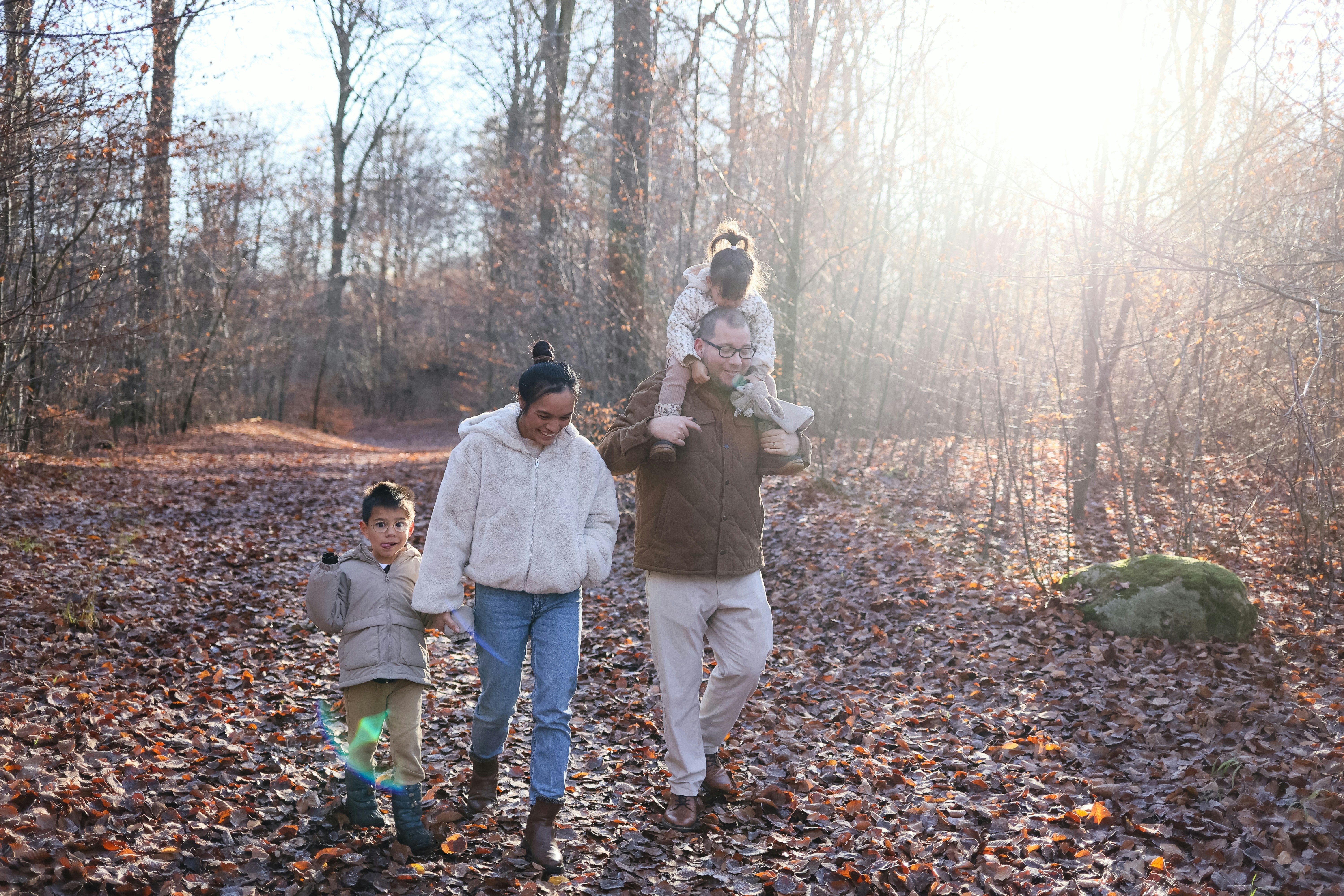 Happy family playing with a Cavapoo puppy in natural light