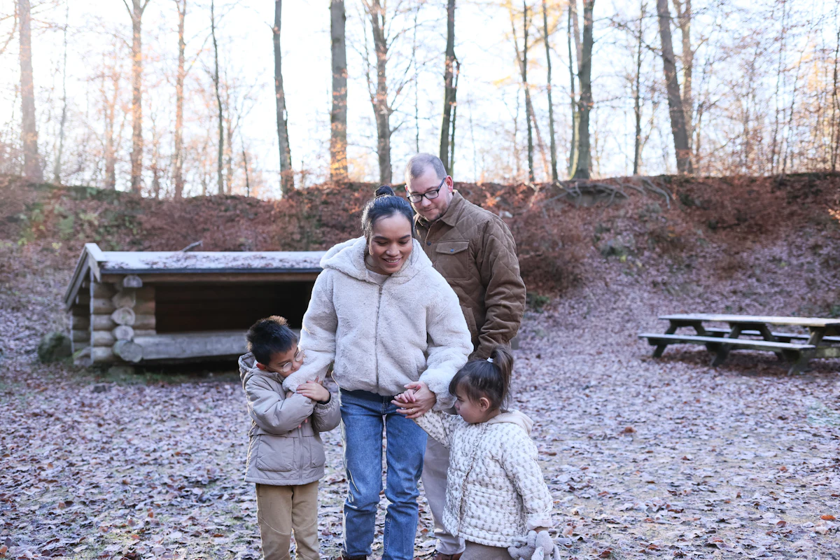 A family walking together through a forest clearing.