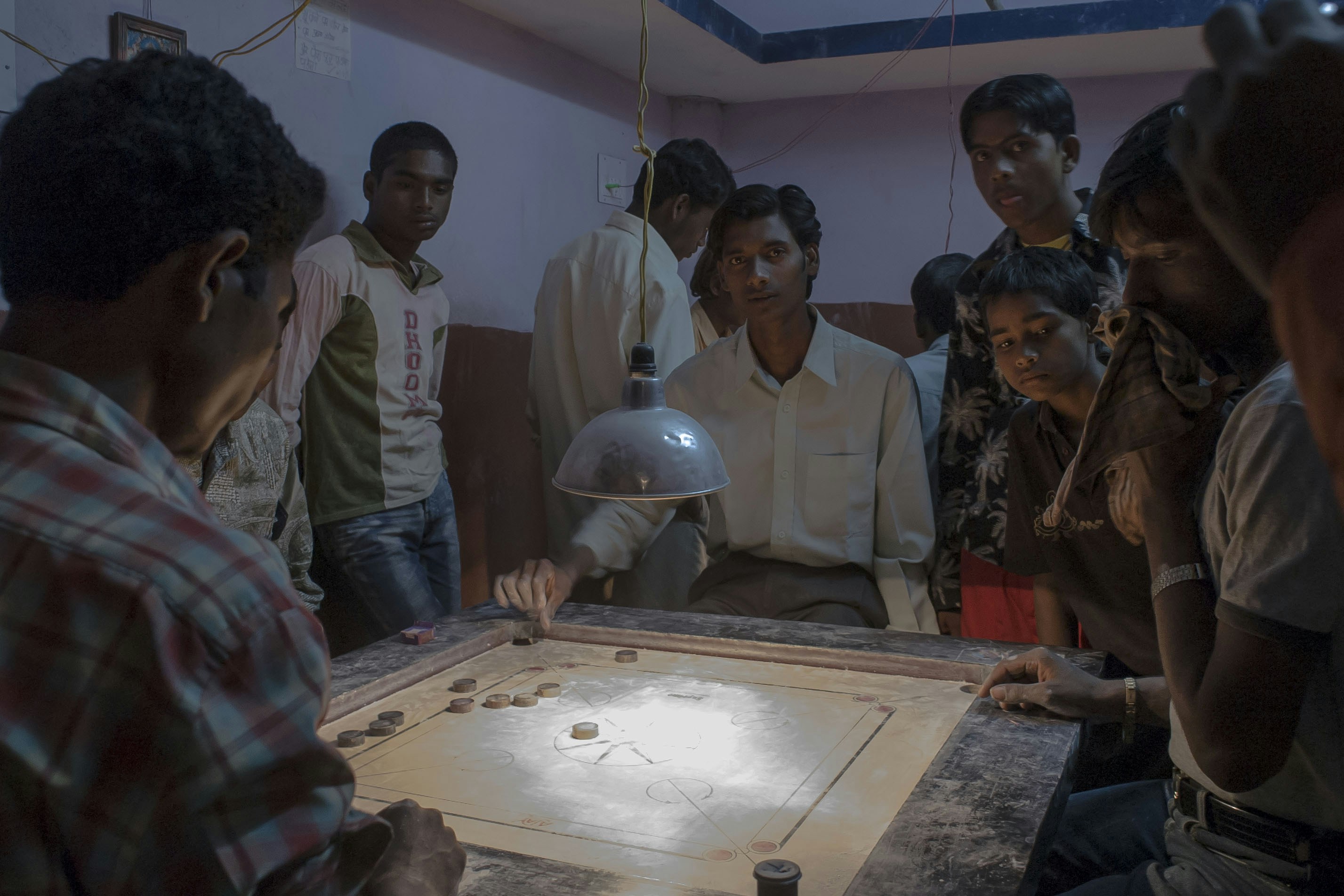 Men playing carrom board game indoors