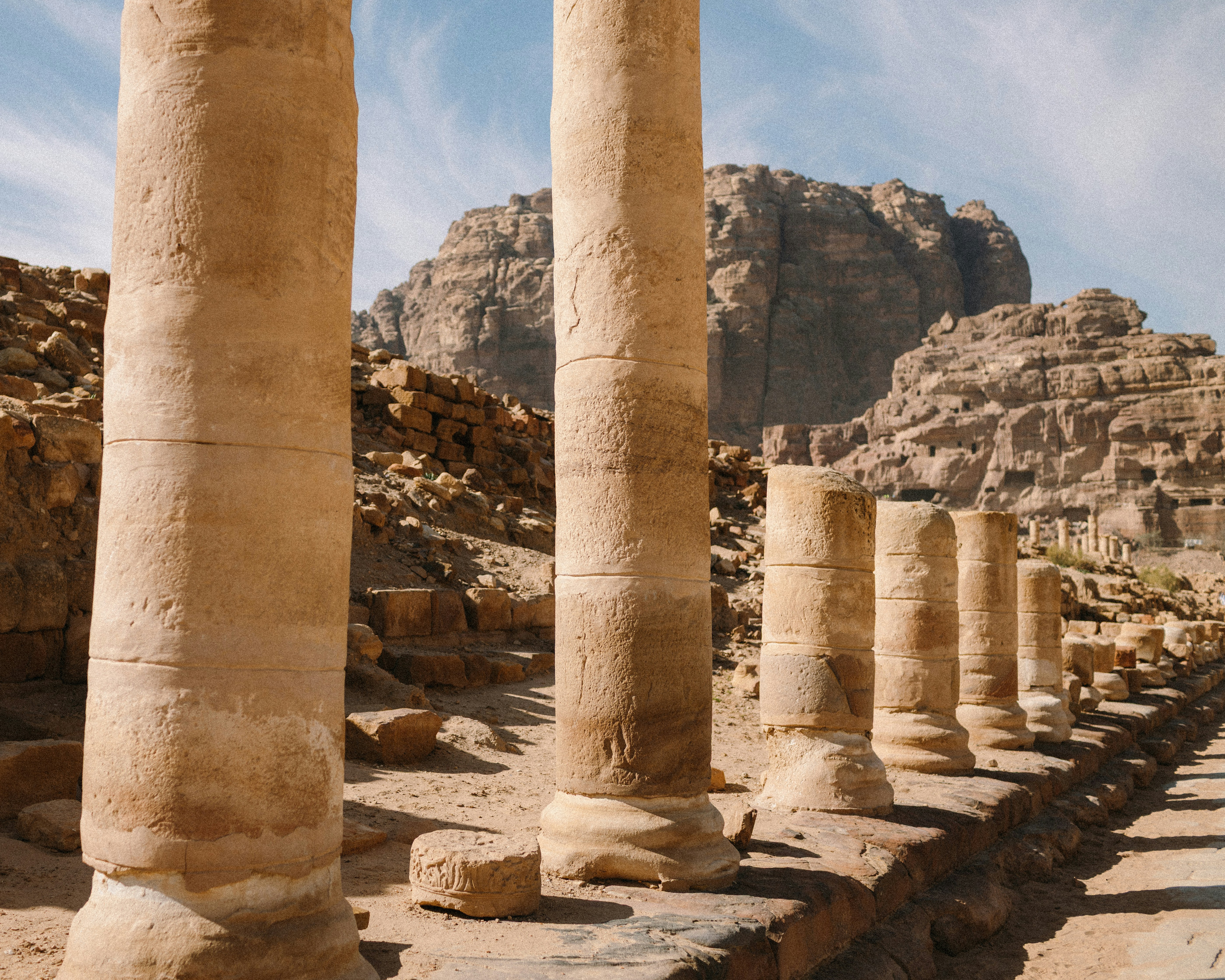 D’anciennes colonnes de pierre se dressent devant des montagnes rocheuses du désert.