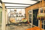 Cozy sunroom with hanging chairs and plants