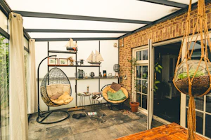 Cozy sunroom with hanging chairs and plants