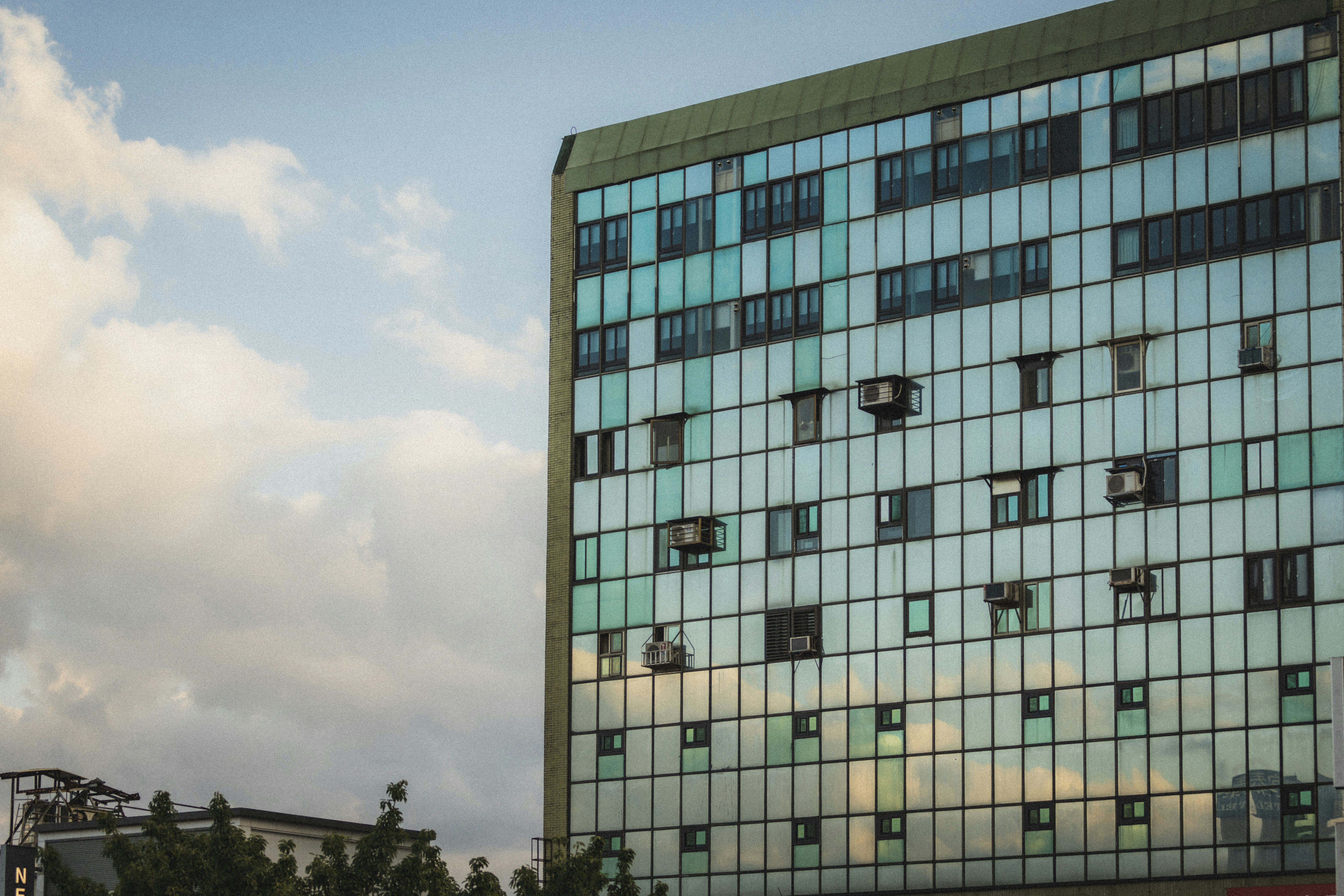 Modern building with reflective glass facade under sky.