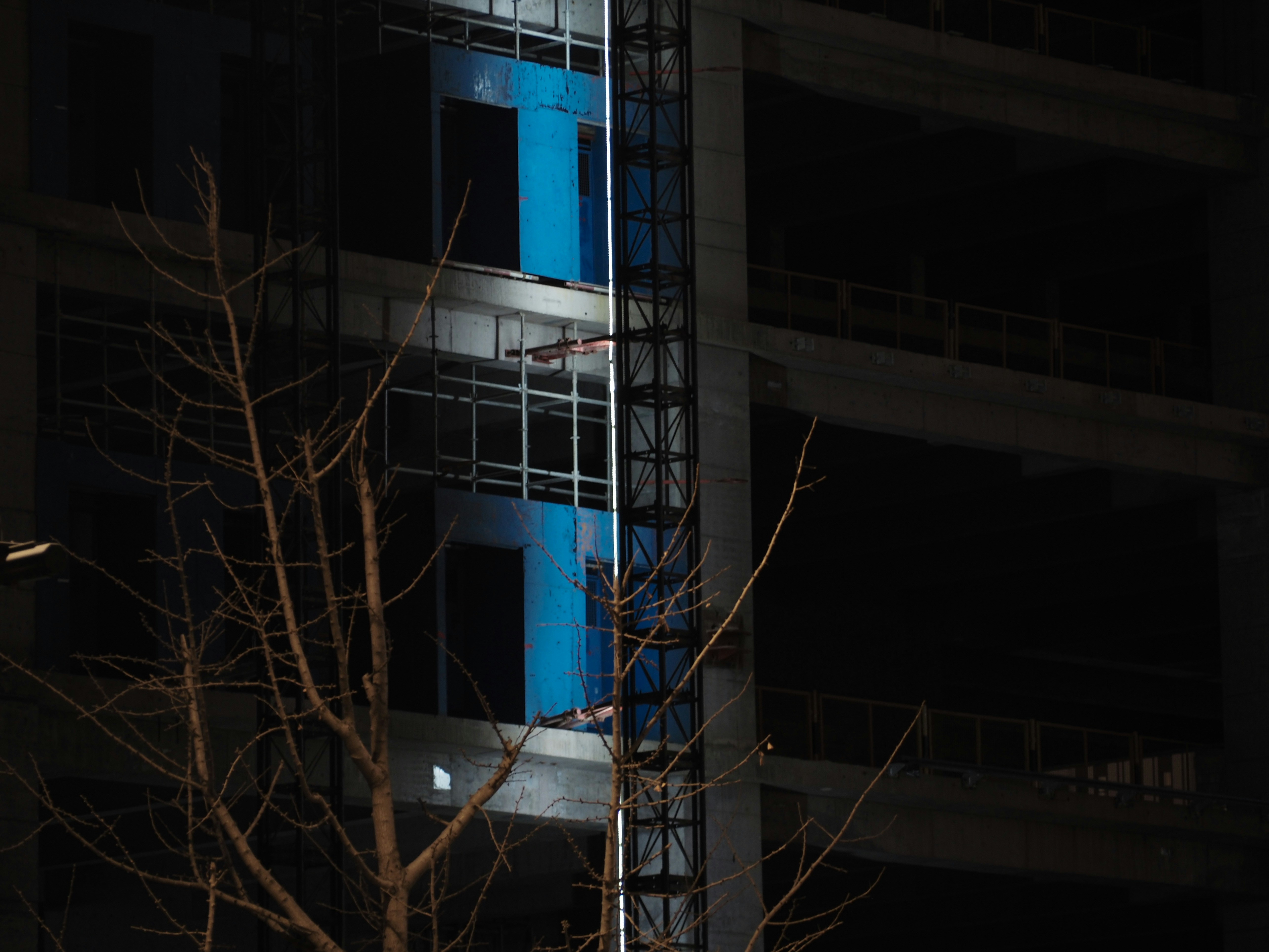 Building under construction at night with blue lights