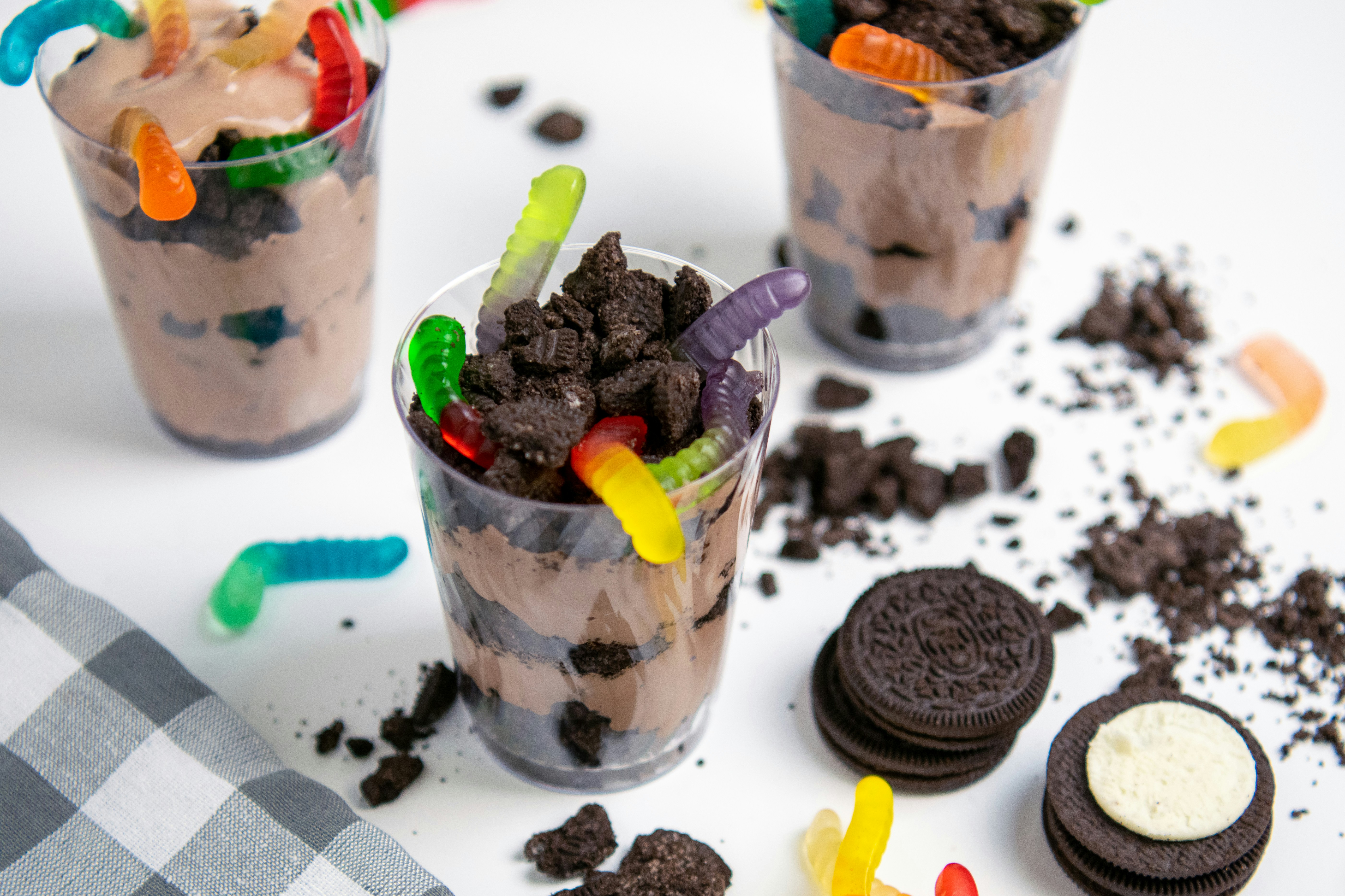 Chocolate pudding cups with crushed cookies and gummy worms