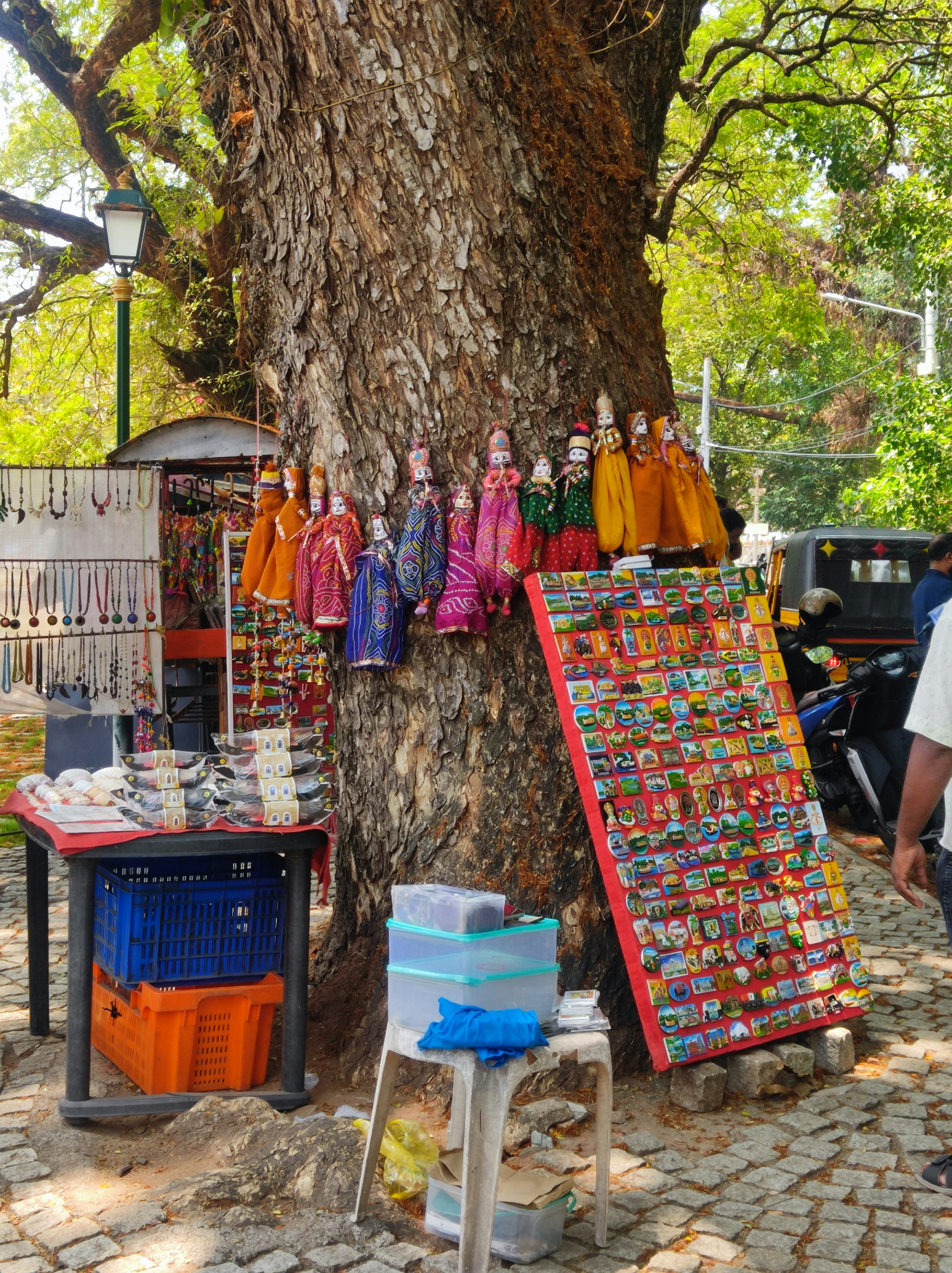 Puppets and souvenirs displayed on a large tree.