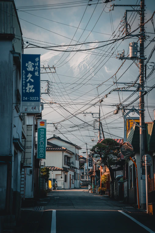 電線越しに山が見える日本の商店街