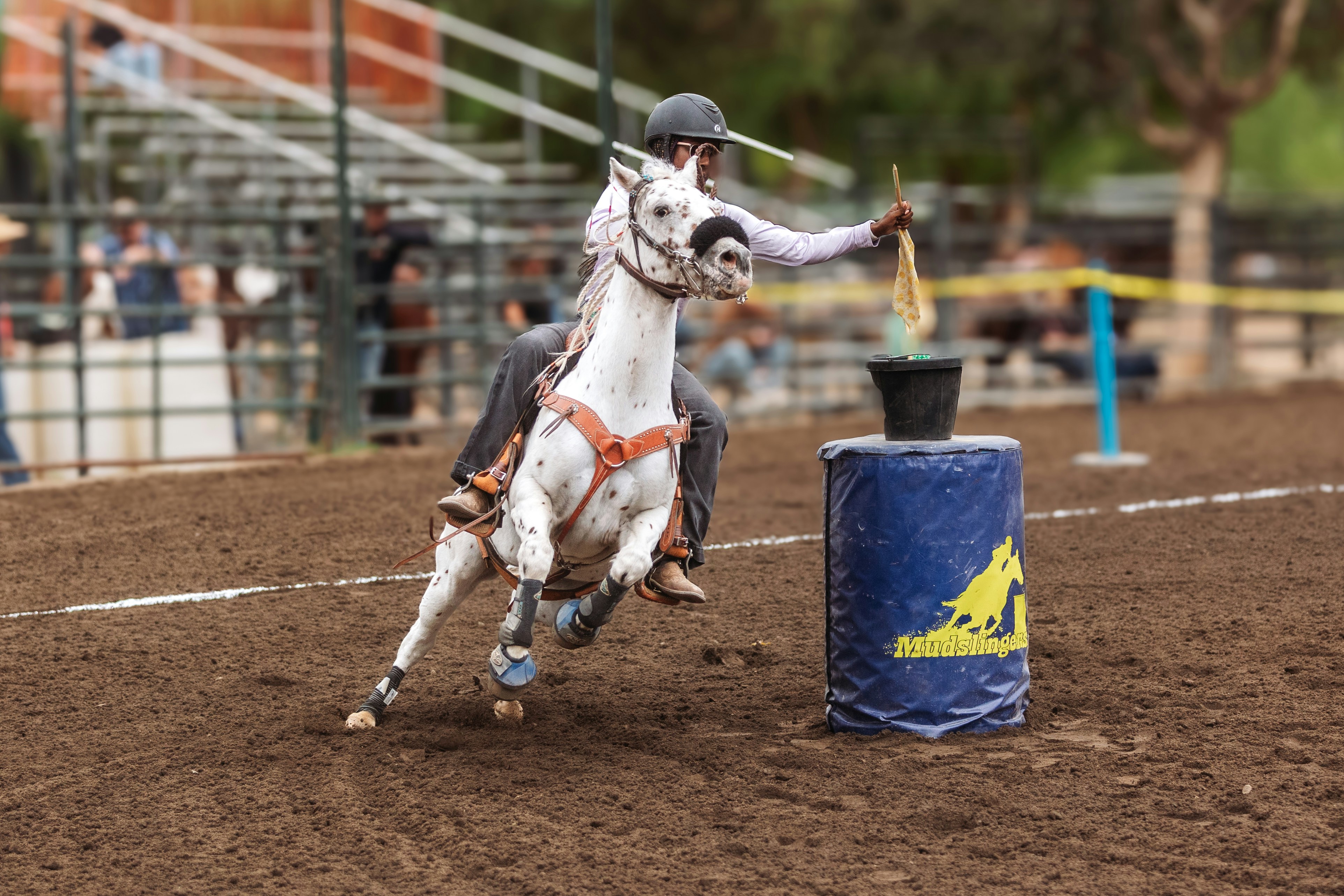 Rider on white horse attempts barrel race event