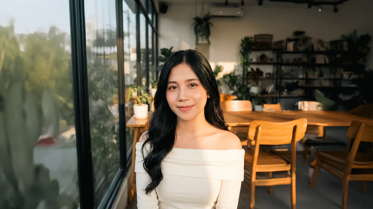 A smiling woman in a plant-decorated caf&eacute;, representing a small business owner