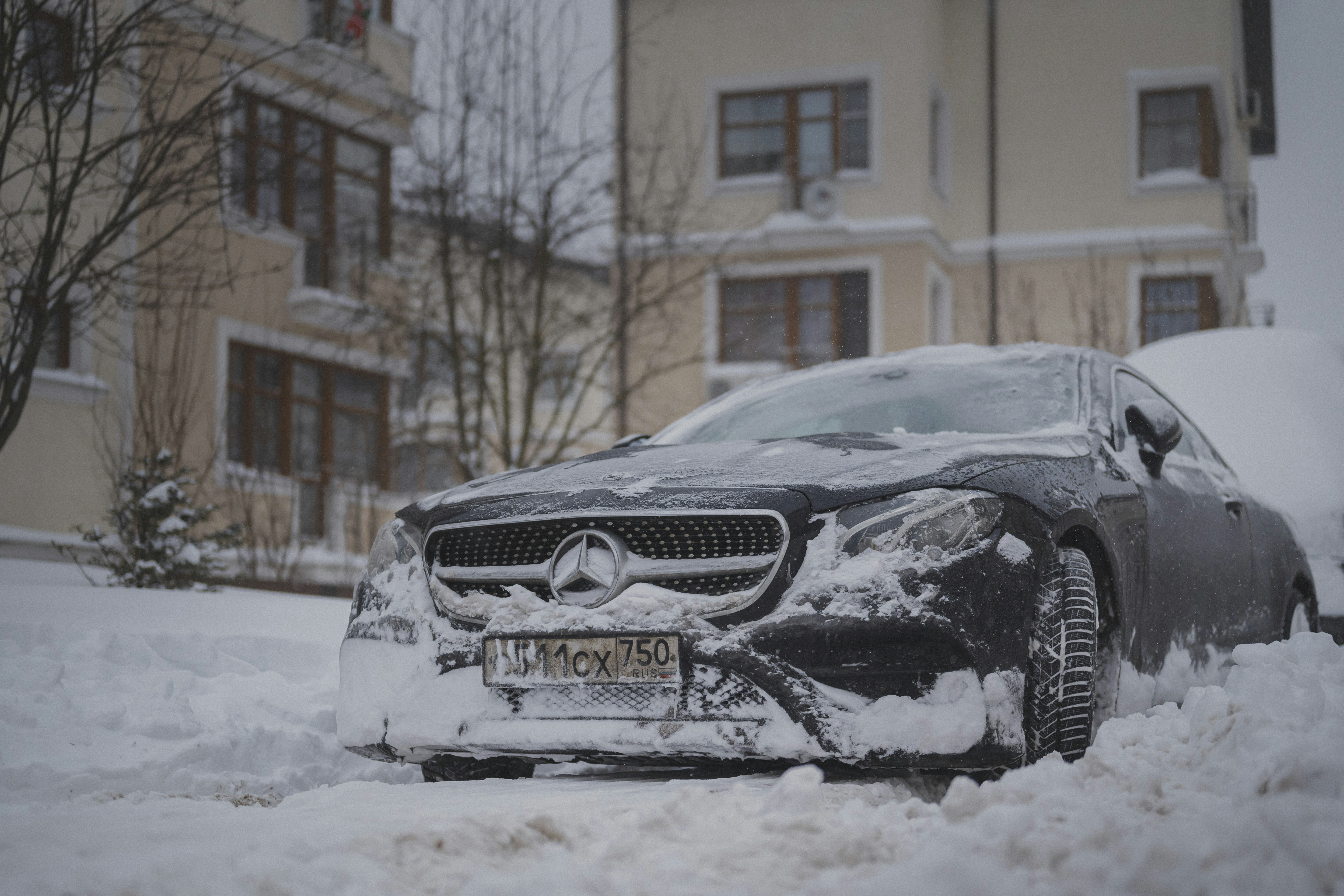 Ein schwarzes Auto, bedeckt mit Schnee auf einer Straße.