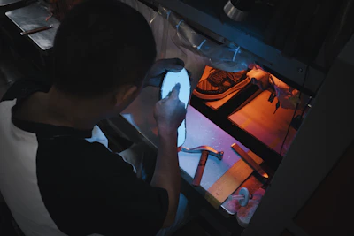 Person examining a glowing blue object under light.