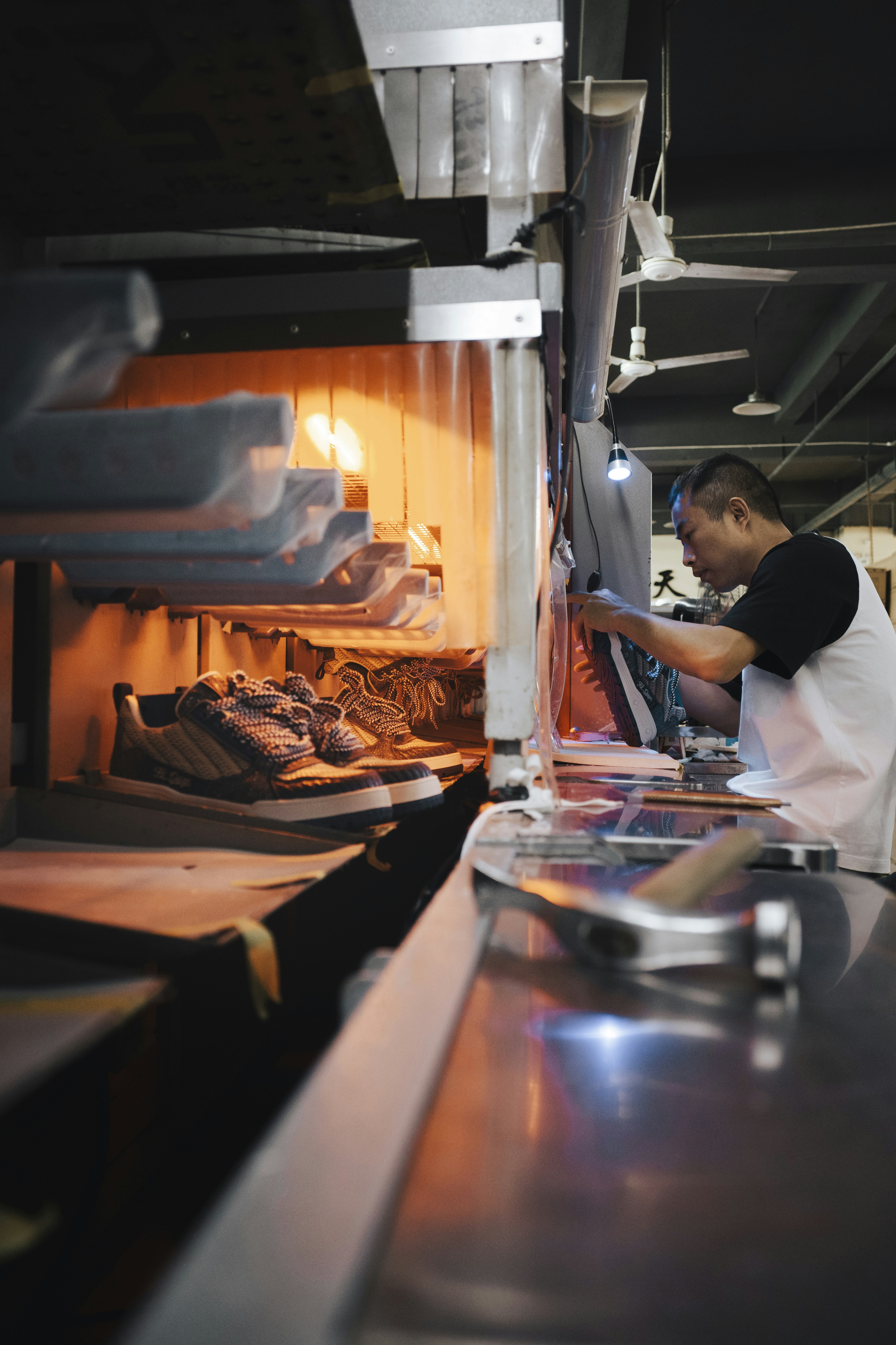 Man working in a shoe factory assembly line.