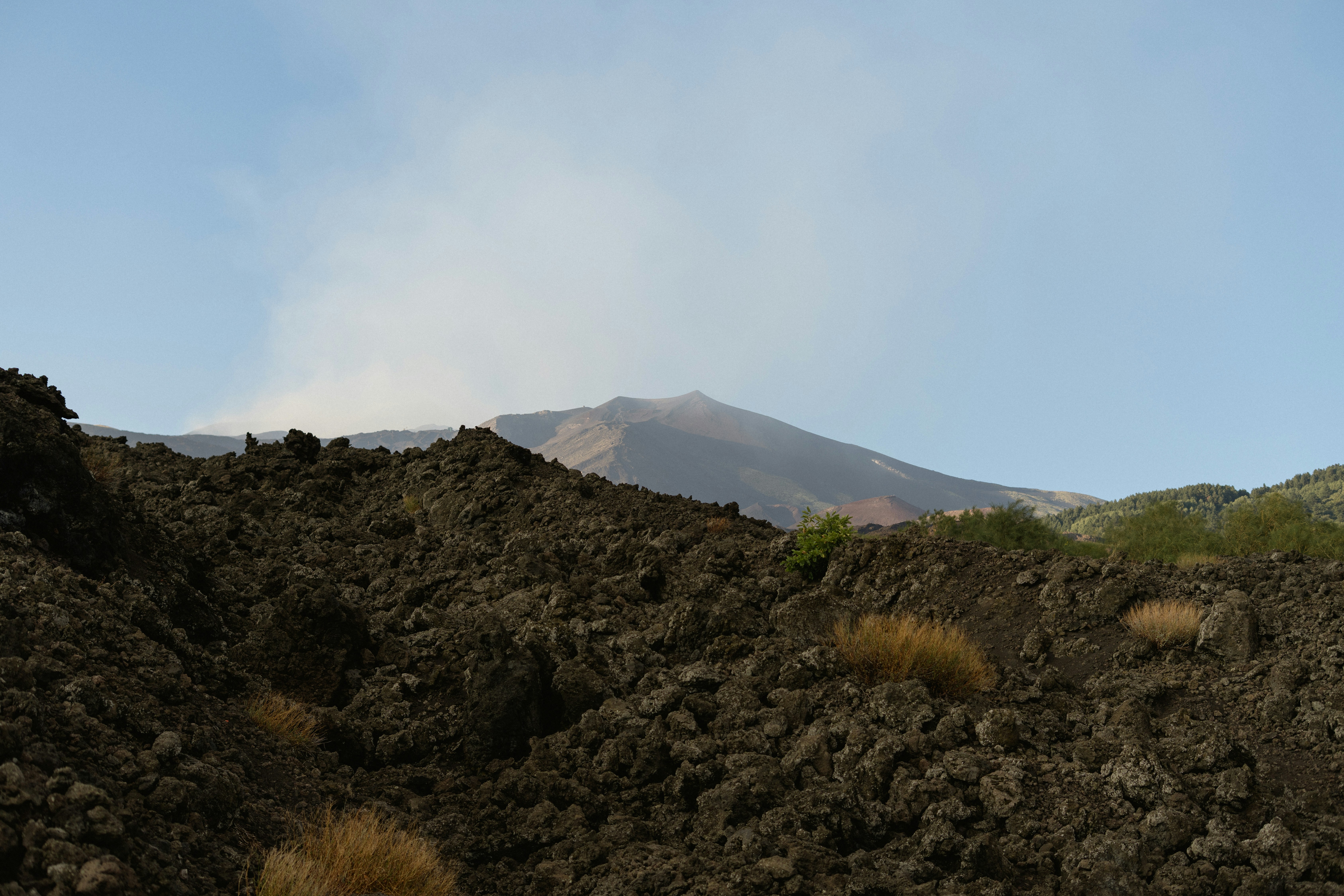Volcano erupting with smoke against a clear blue sky