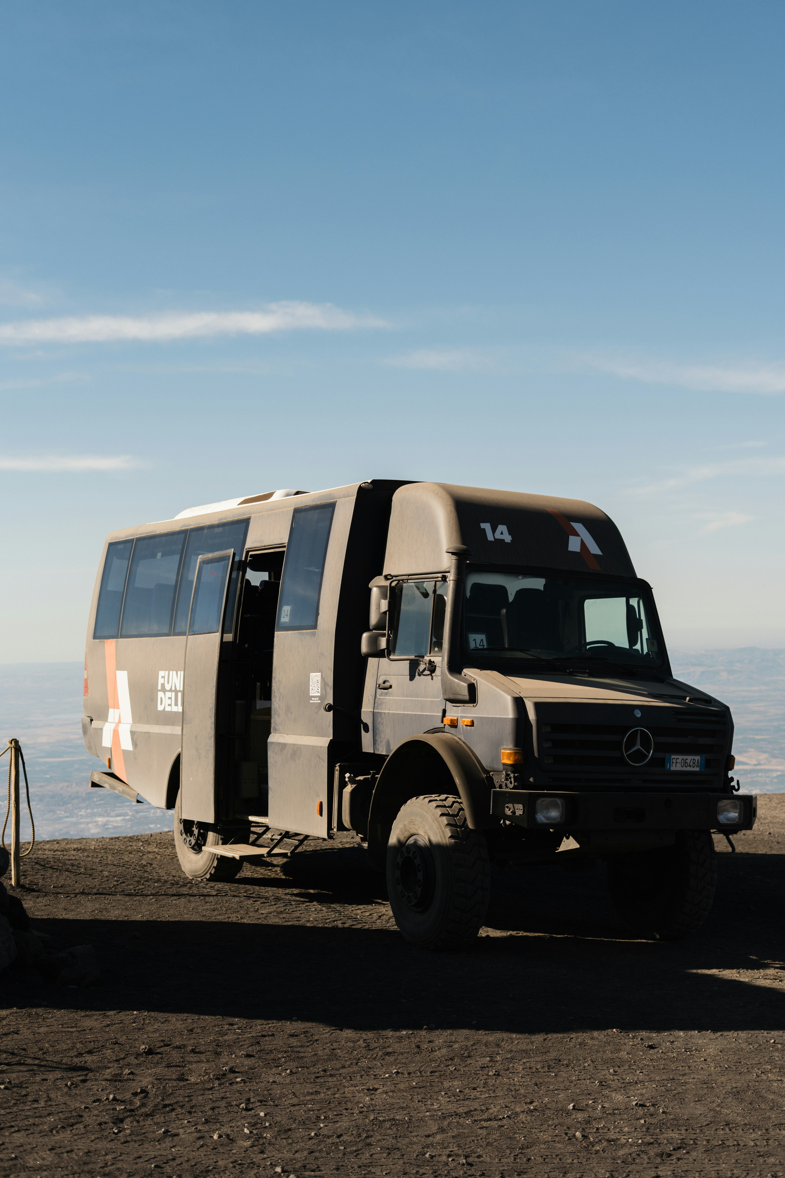 A rugged bus parked on a dirt road