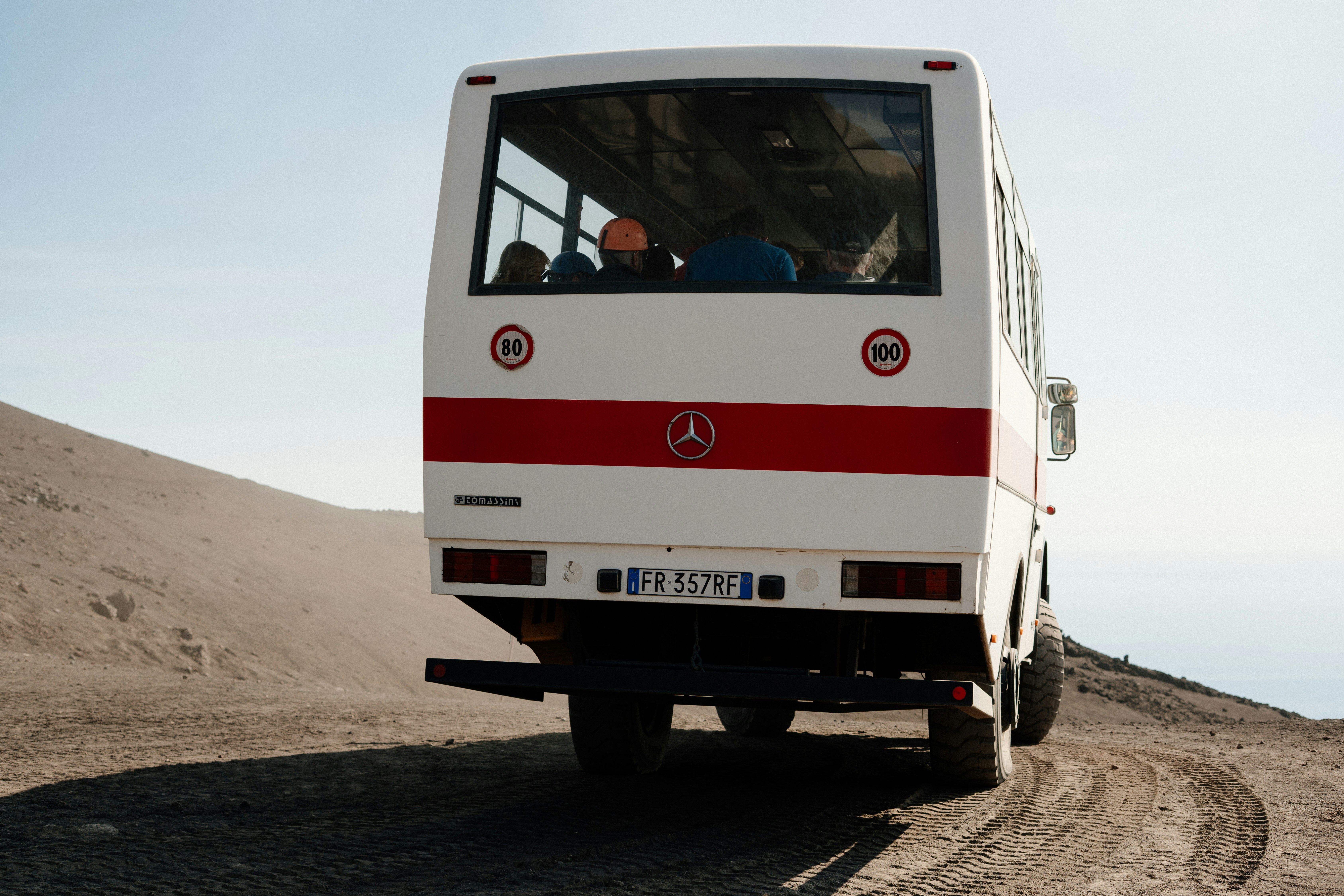 White bus driving on a dusty road