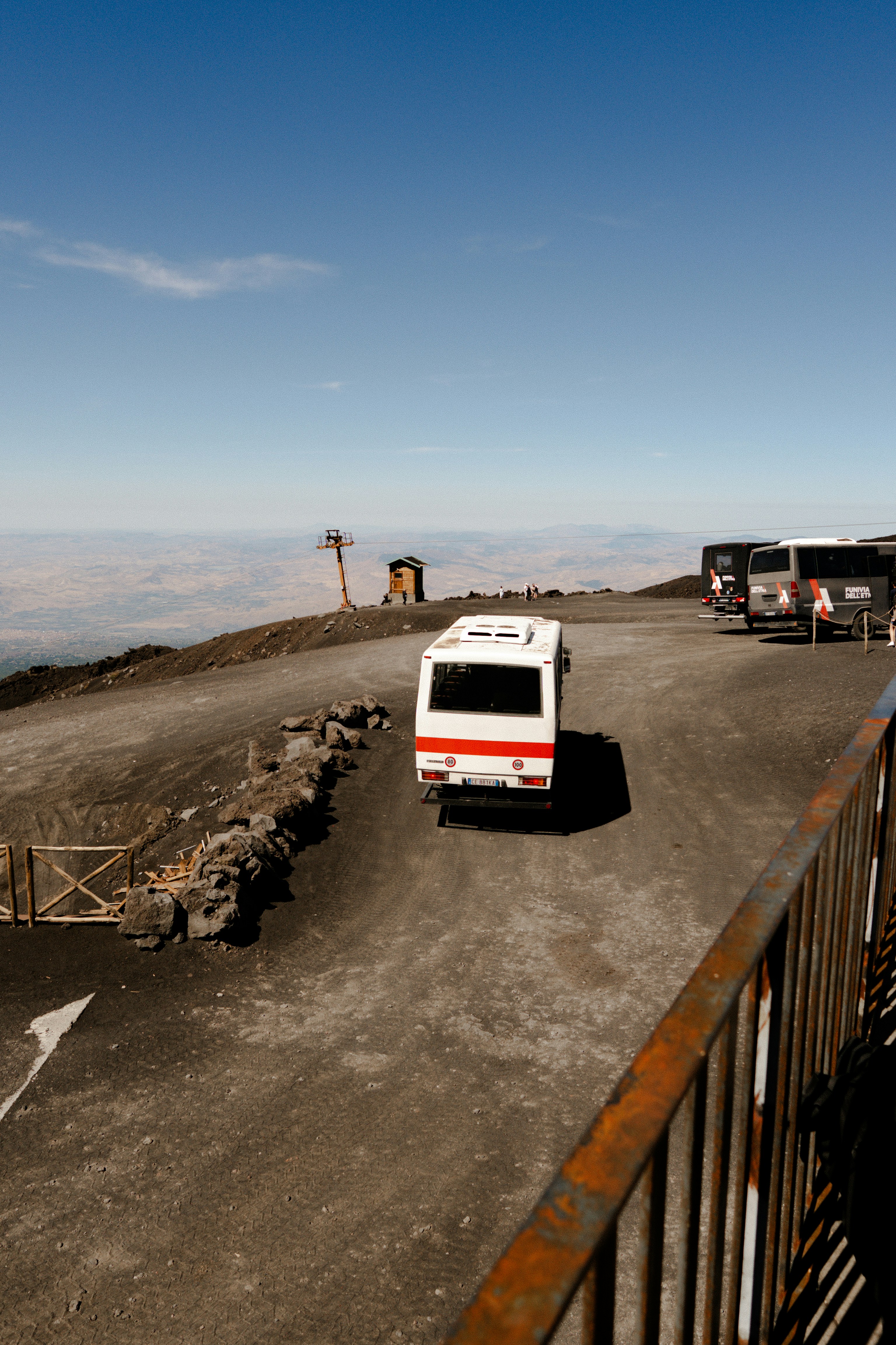 White bus parked on a dirt road with mountains