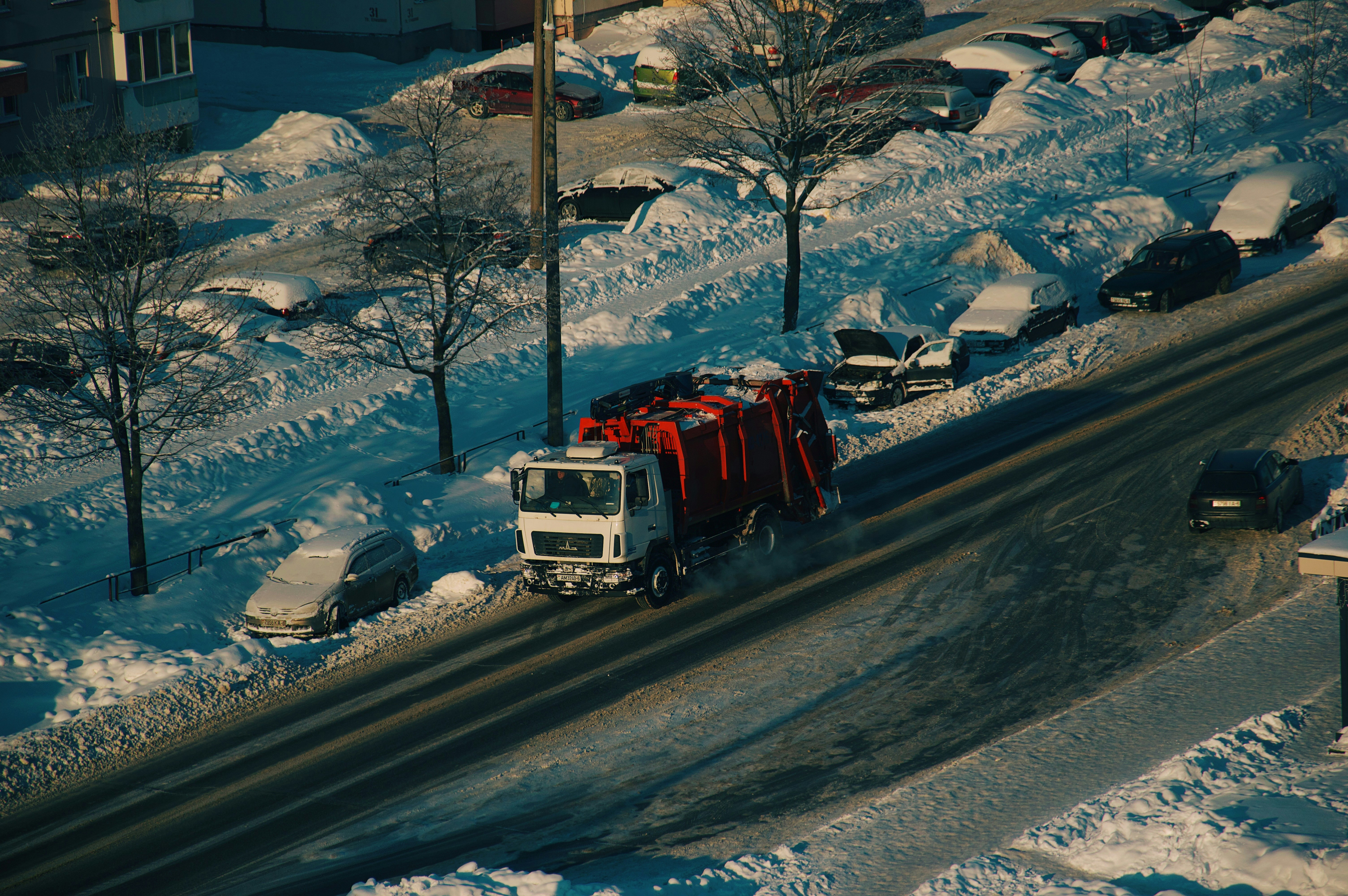 Garbage truck driving on a snowy street