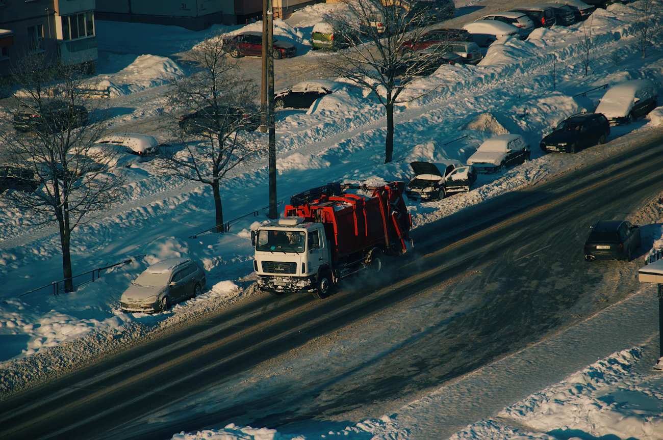 雪の道路を走るゴミ収集車