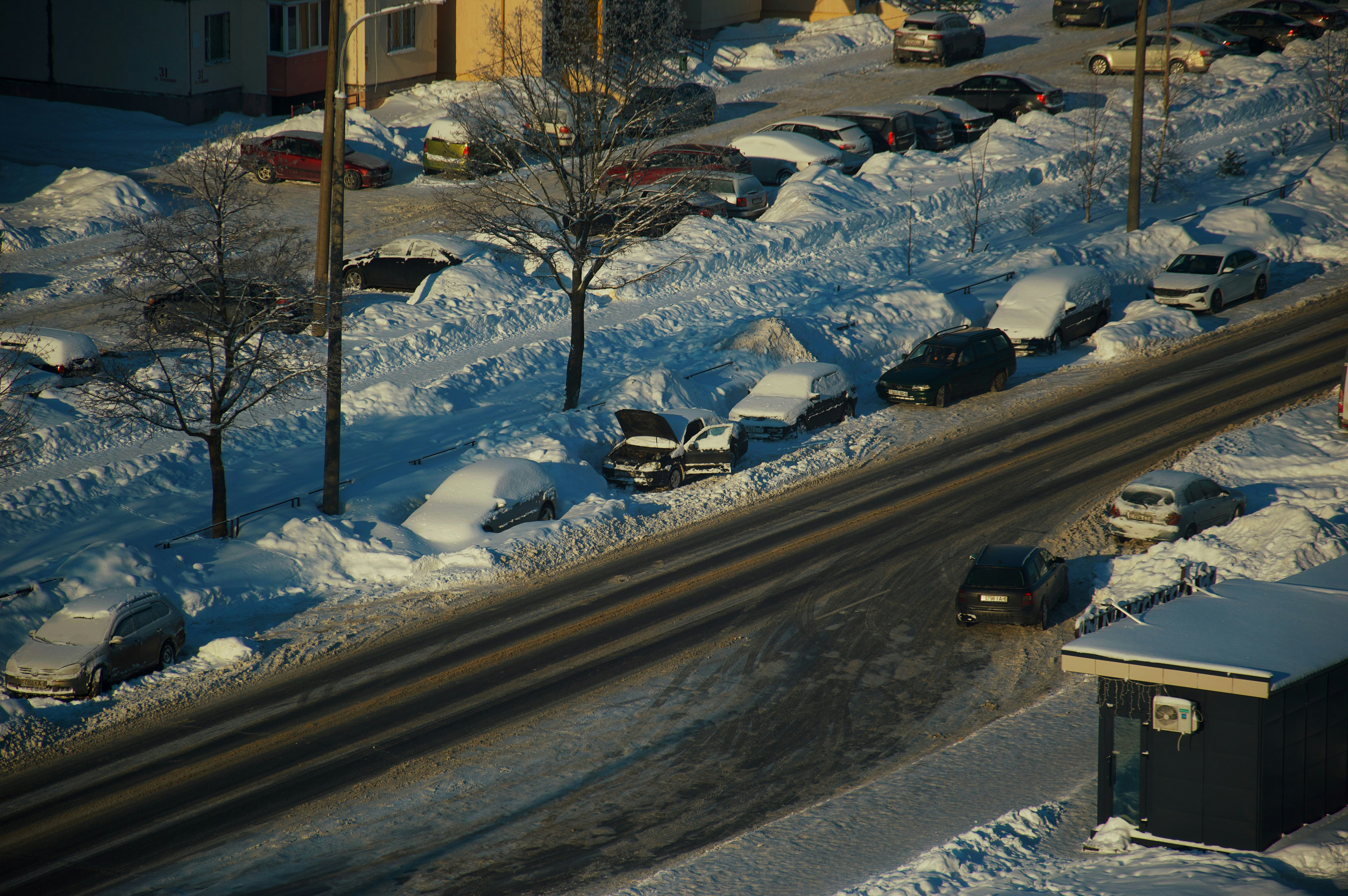 Cars parked along a snow-covered street in winter.