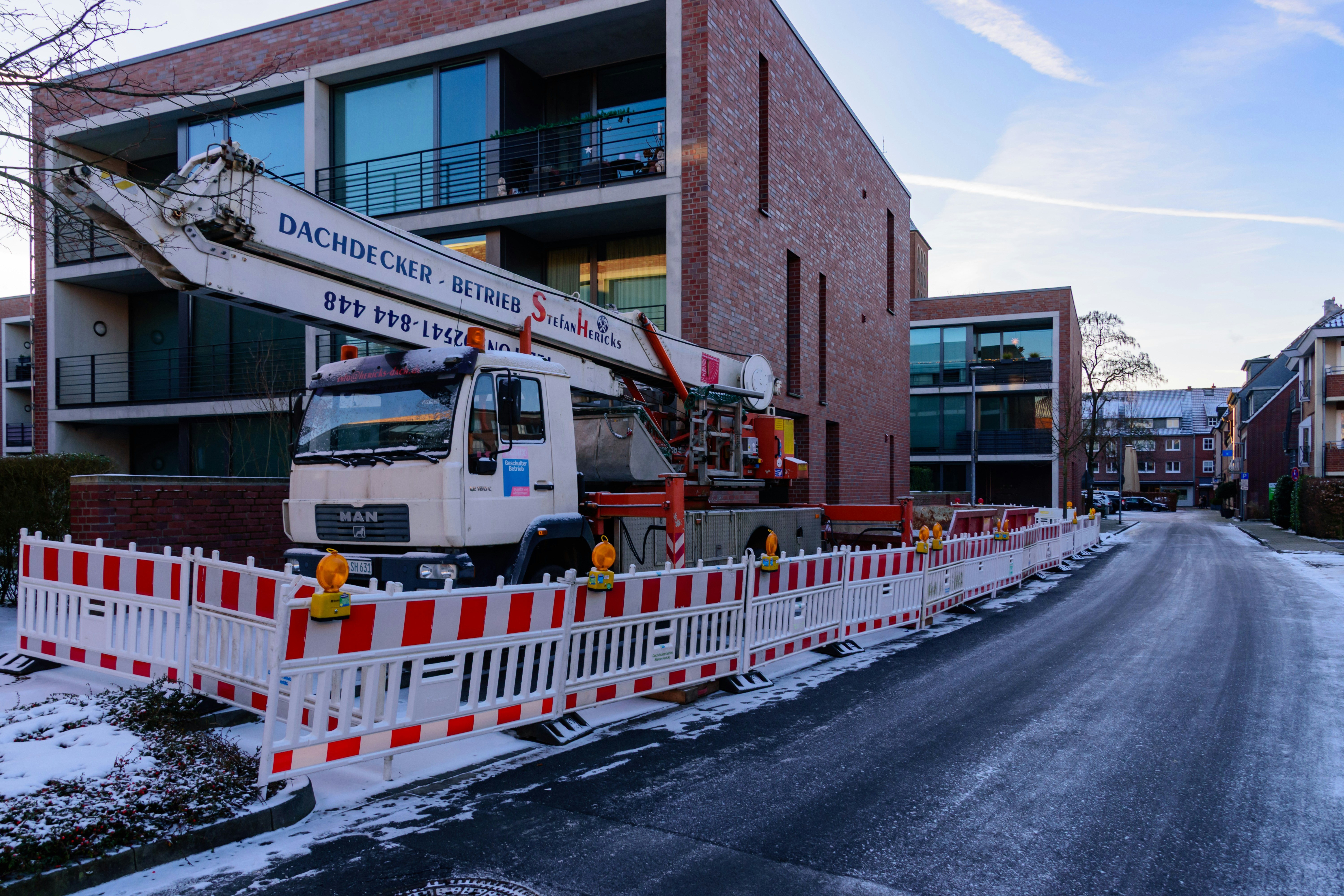 Crane truck parked beside a building with snow on ground