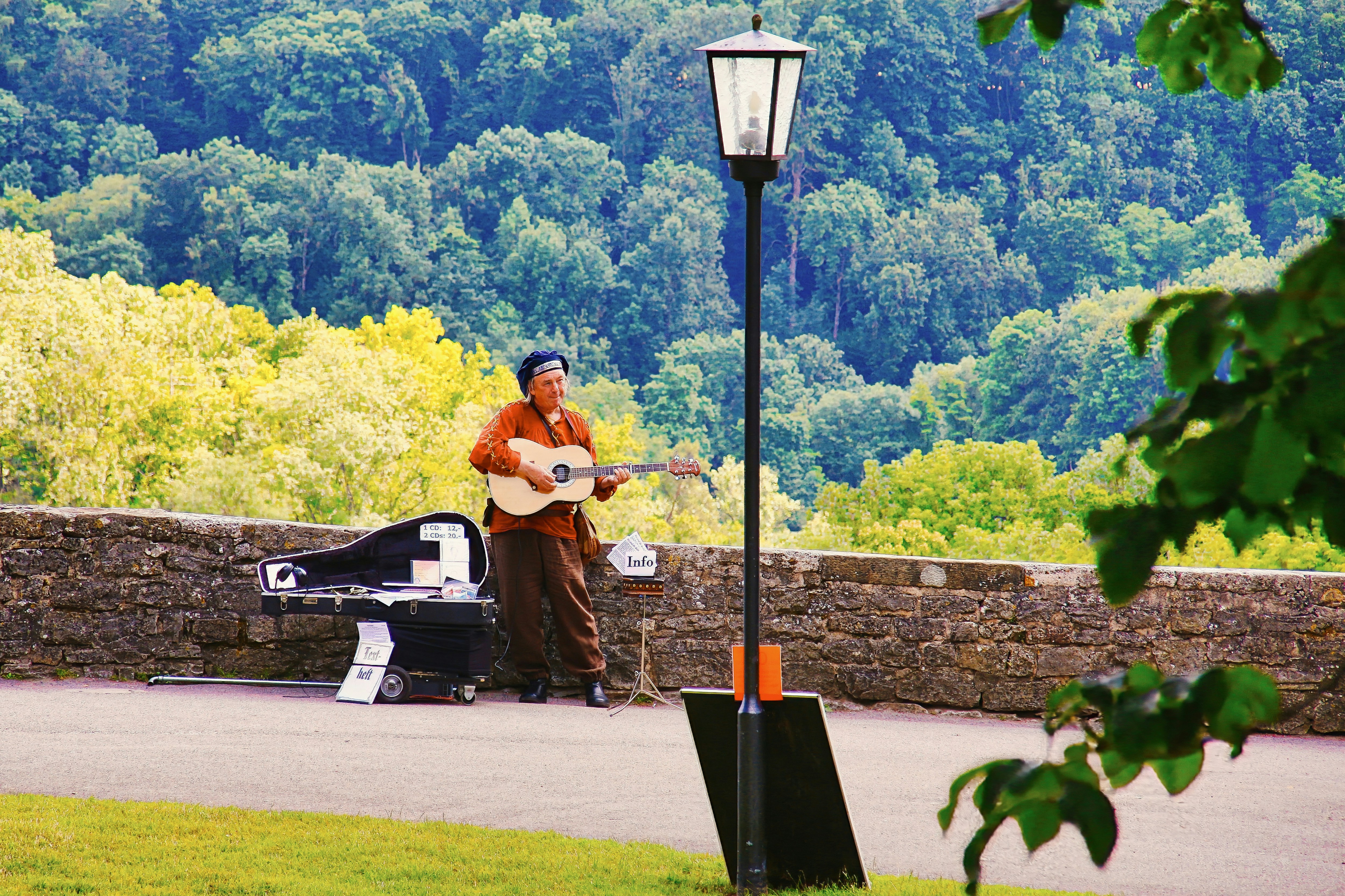 Man playing guitar by a stone wall