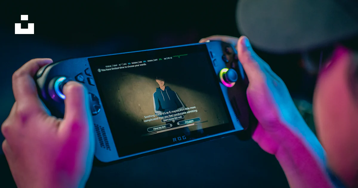 Person holding a portable gaming console playing a video. photo – Free ...