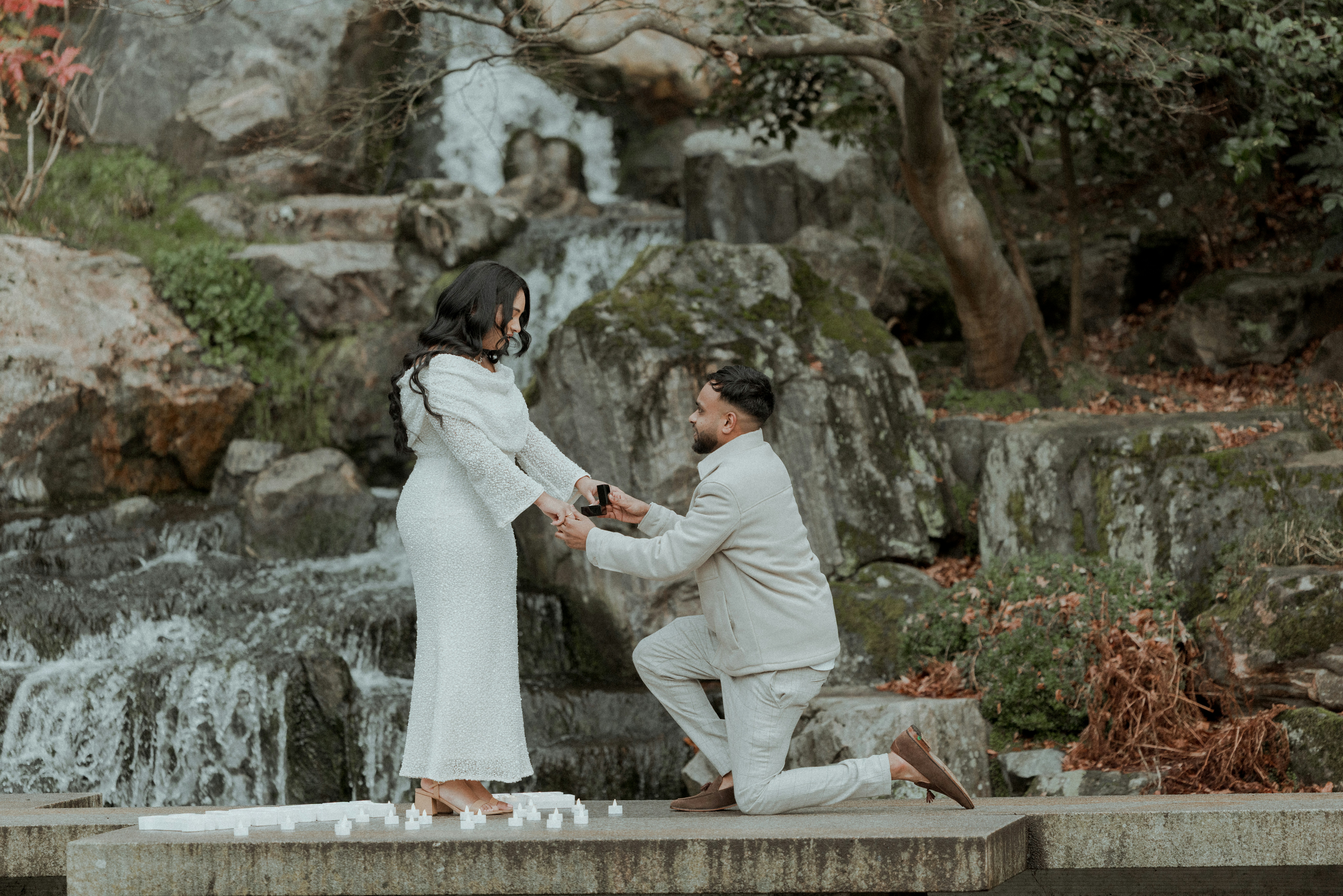Man proposes to woman by a waterfall