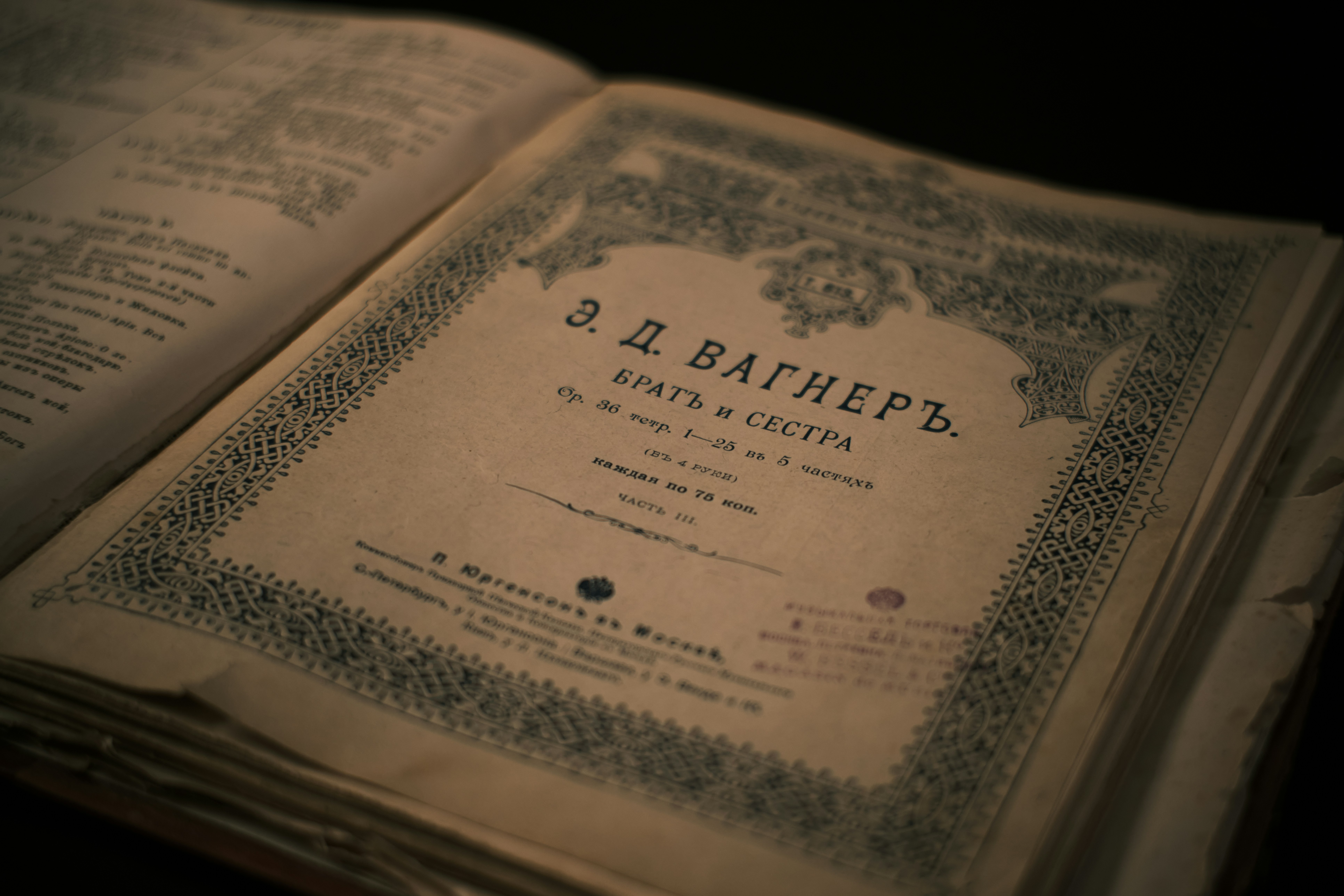 Un viejo libro abierto con una portada decorativa.