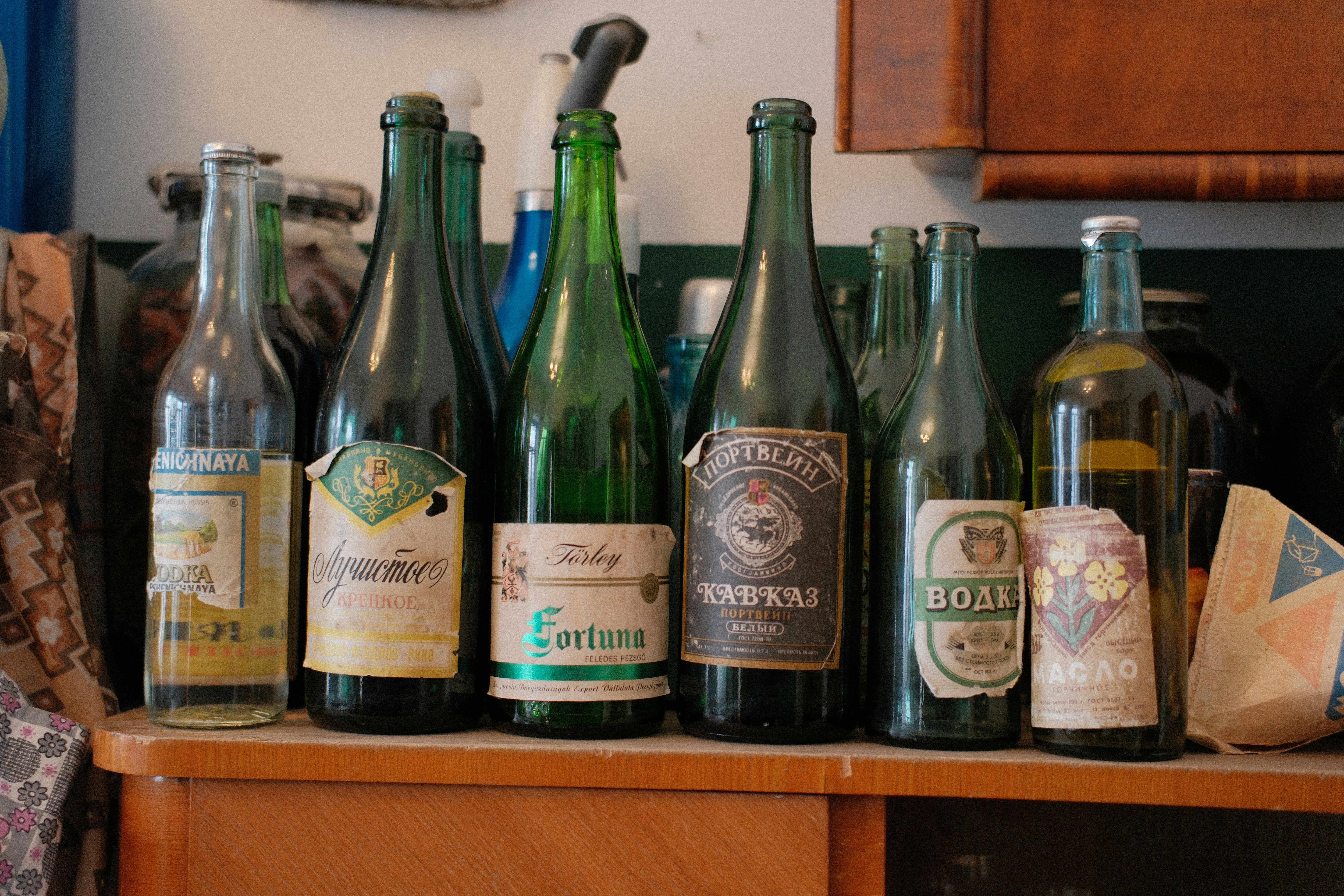 Collection de vieilles bouteilles en verre avec étiquettes sur l’étagère